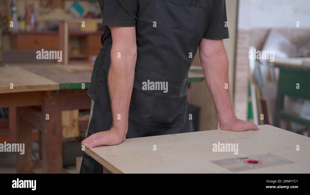 Besorgter Inhaber Eines Kleinen Unternehmens, Der In Der Tischlerei Steht Und Sich Sorgen Um Den Wirtschaftsabschwung Macht, Senior Person, Die Schürze Trägt, Feeling Str Stockfoto