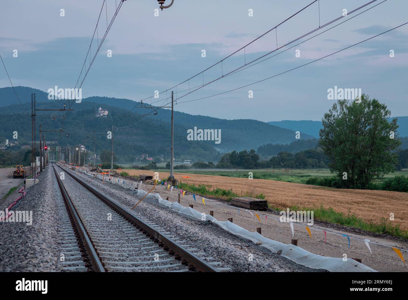 Renovierung der Gleisanlagen. Doppelschienenbahnen, von denen eine demontiert, die obere Schicht entfernt und erneuert wird. In der Nähe wird eine moderne Eisenbahnstrecke gebaut Stockfoto