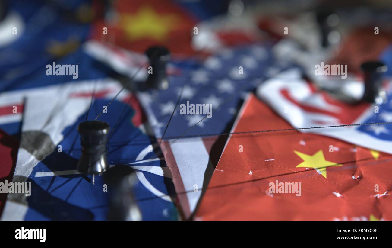 China, NATO, USA, Flaggen, verschlungene Trittstufen und Stecknadel Stockfoto