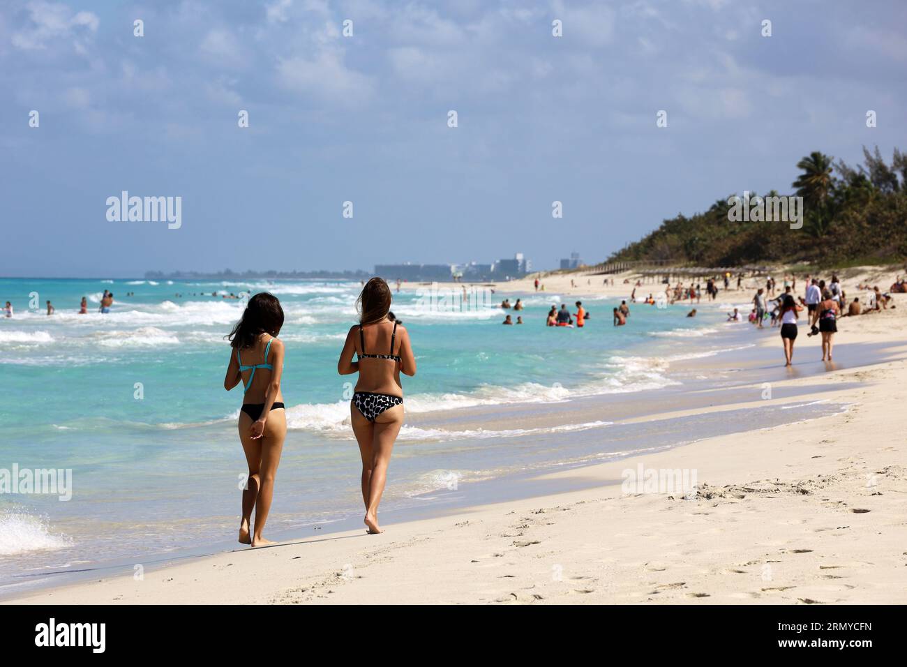 Zwei Mädchen im Bikini, die am tropischen Strand durch den Sand laufen. Ocean Coast, Touristenresort auf sonniger Insel Stockfoto