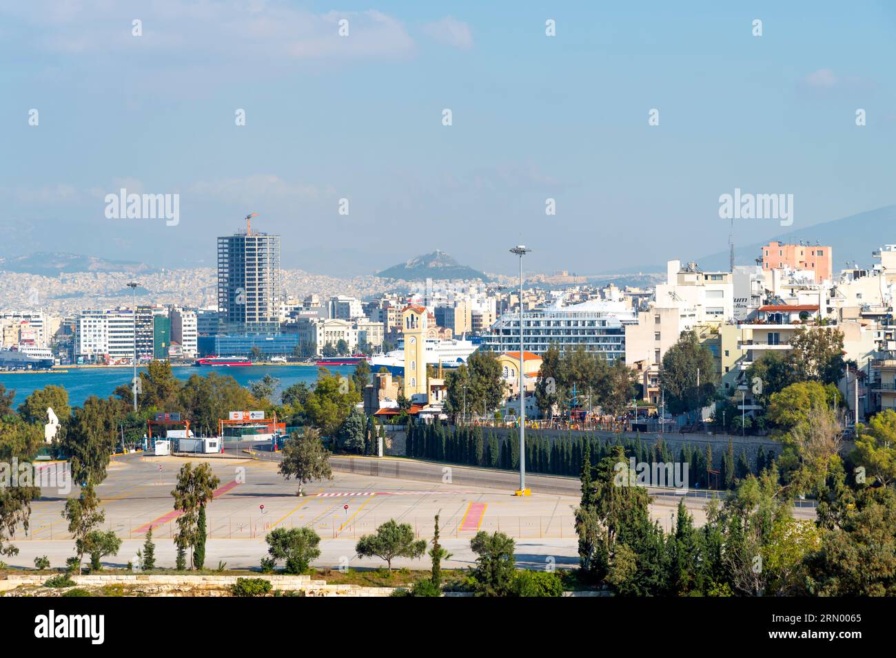 Blick auf Athen, den Parthenon-Tempel und das Propyläen-Tor auf dem Akropolis-Hügel, mit dem Berg Lycabettus hinter, vom Hafen Piräus Griechenland. Stockfoto
