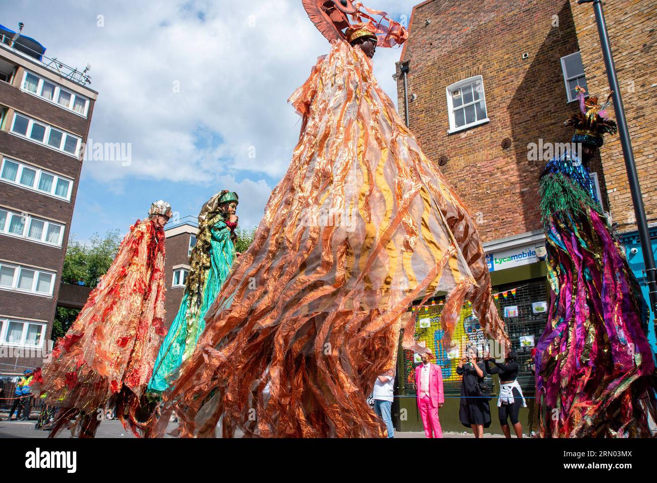 London, Großbritannien. 28. August 2023. Die Leute sahen auf Stelzen während der Parade des Notting Hill Carnival in London zu Fuß gehen. Der Notting Hill Carnival ist eines der größten Straßenfeste der Welt. Es begann 1966, entstand aber aus dem Karibischen Karneval, der 1959 mit der Immigrantengemeinschaft aus Trinidad und Tobago organisiert wurde. In diesem Jahr feiert der Notting Hill Carnival den 50. Jahrestag der Einführung der Soundsysteme und Mas-Bands. Außerdem jährt sich der 75. Jahrestag der Ankunft der Passagiere der Empire Windrush in Großbritannien. (Bild: © Krisztian Elek/SOPA Stockfoto