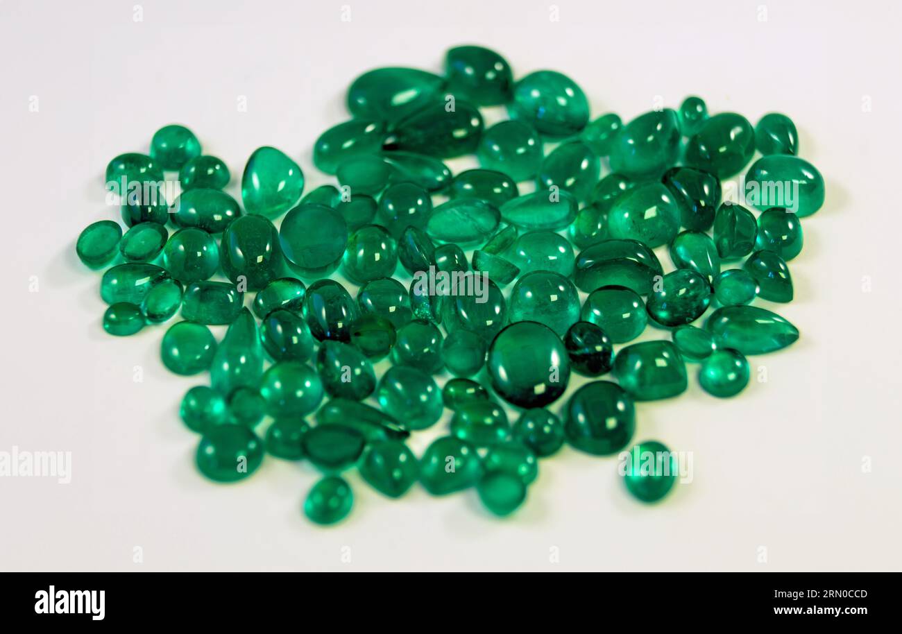 Grüne Smaragde aus Muzo, Coscuez und Chivor Kolumbien, isoliert auf weißem Hintergrund Prinzessin geschnittenes Juwel Rundgeschnittenes Juwel Smaragd geschnittenes Juwel Ovales Juwel, C Stockfoto