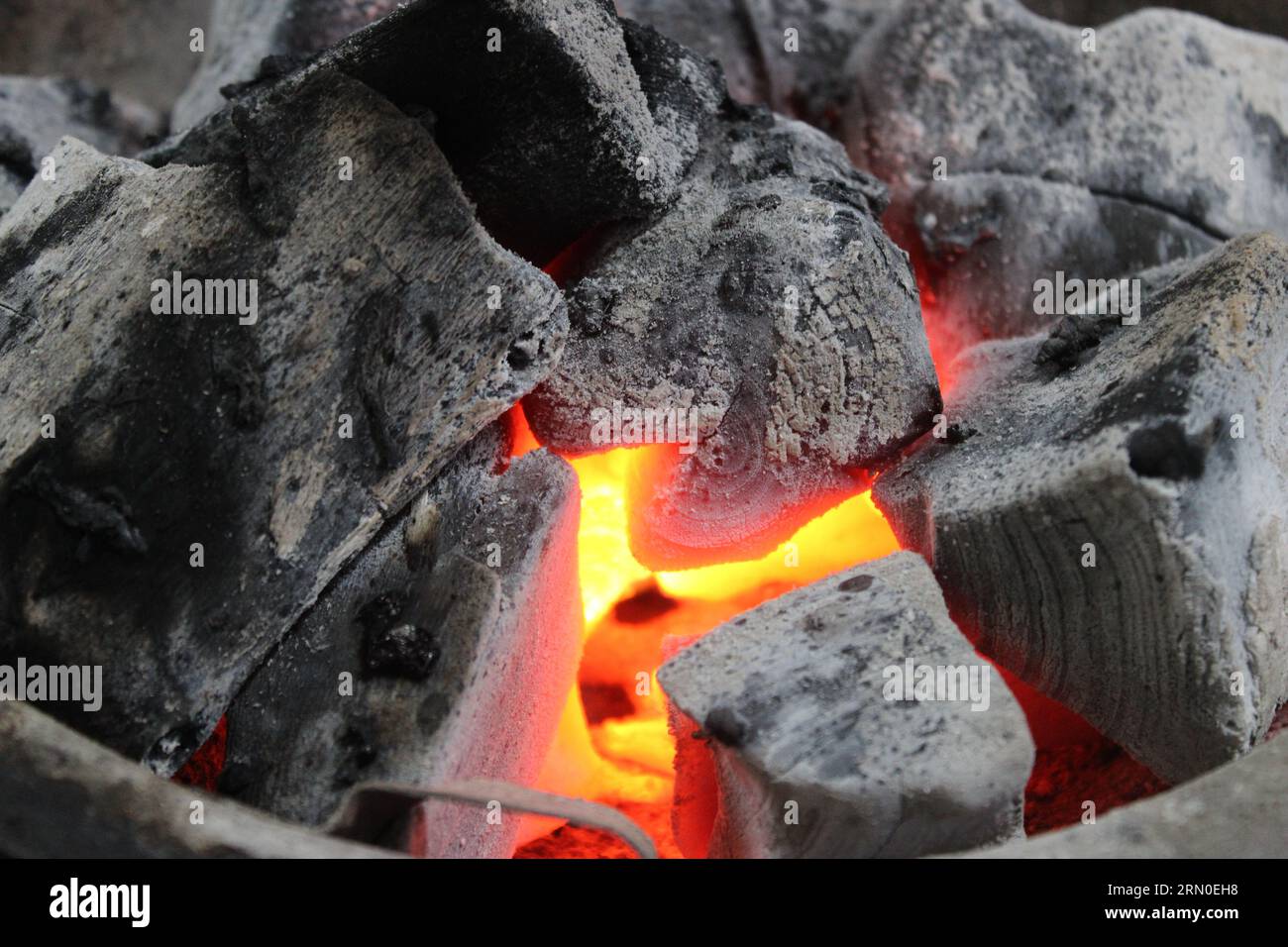 Feuer brennt unter heißen Kohlen, im Grill Stockfoto