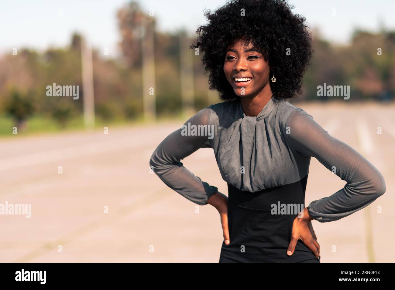 Schöne afroamerikanische Frau mit Lächeln und Ausdruck von Freude, Zufriedenheit und Feier Stockfoto