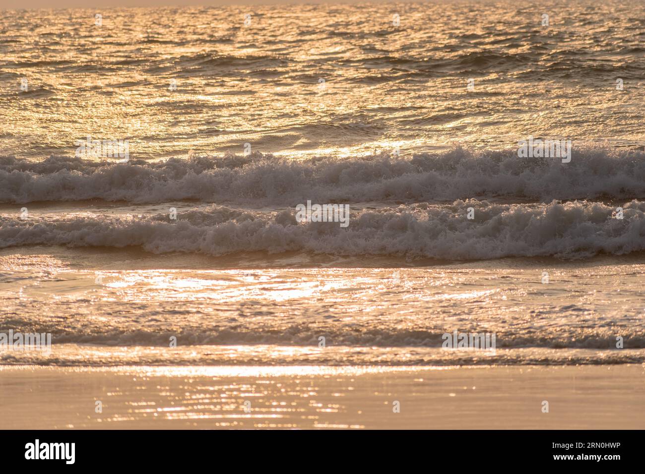 Abendlicht, das die Wellen des Ozeans an einem Strand in Goa trifft. Stockfoto