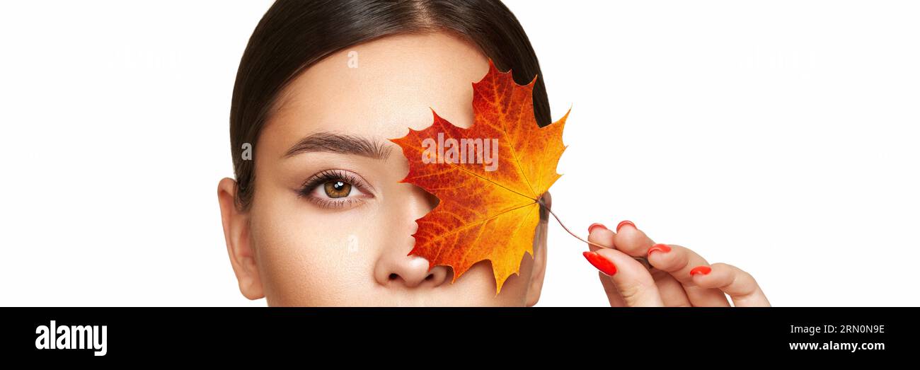 Porträt einer schönen jungen Frau mit Herbstblättern. Gesunde saubere frische Haut natürliche Make-up Beauty-Augen und rote Nägel Stockfoto