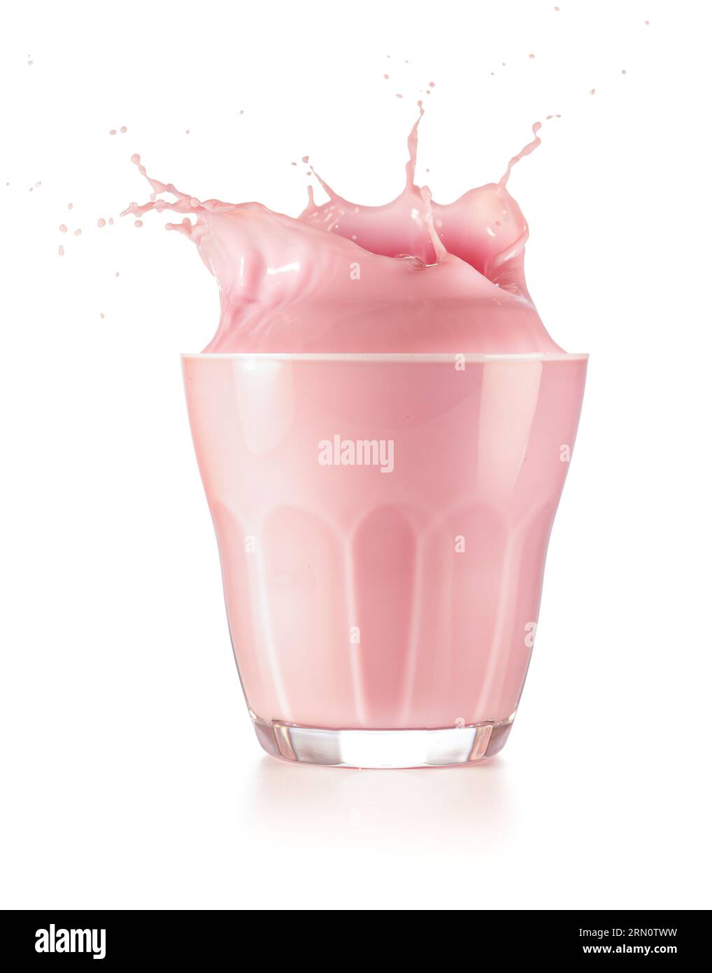 Rosafarbener Milchshake, der aus dem Trinkglas auf weißem Hintergrund spritzt. Authentische Studioaufnahme. Stockfoto
