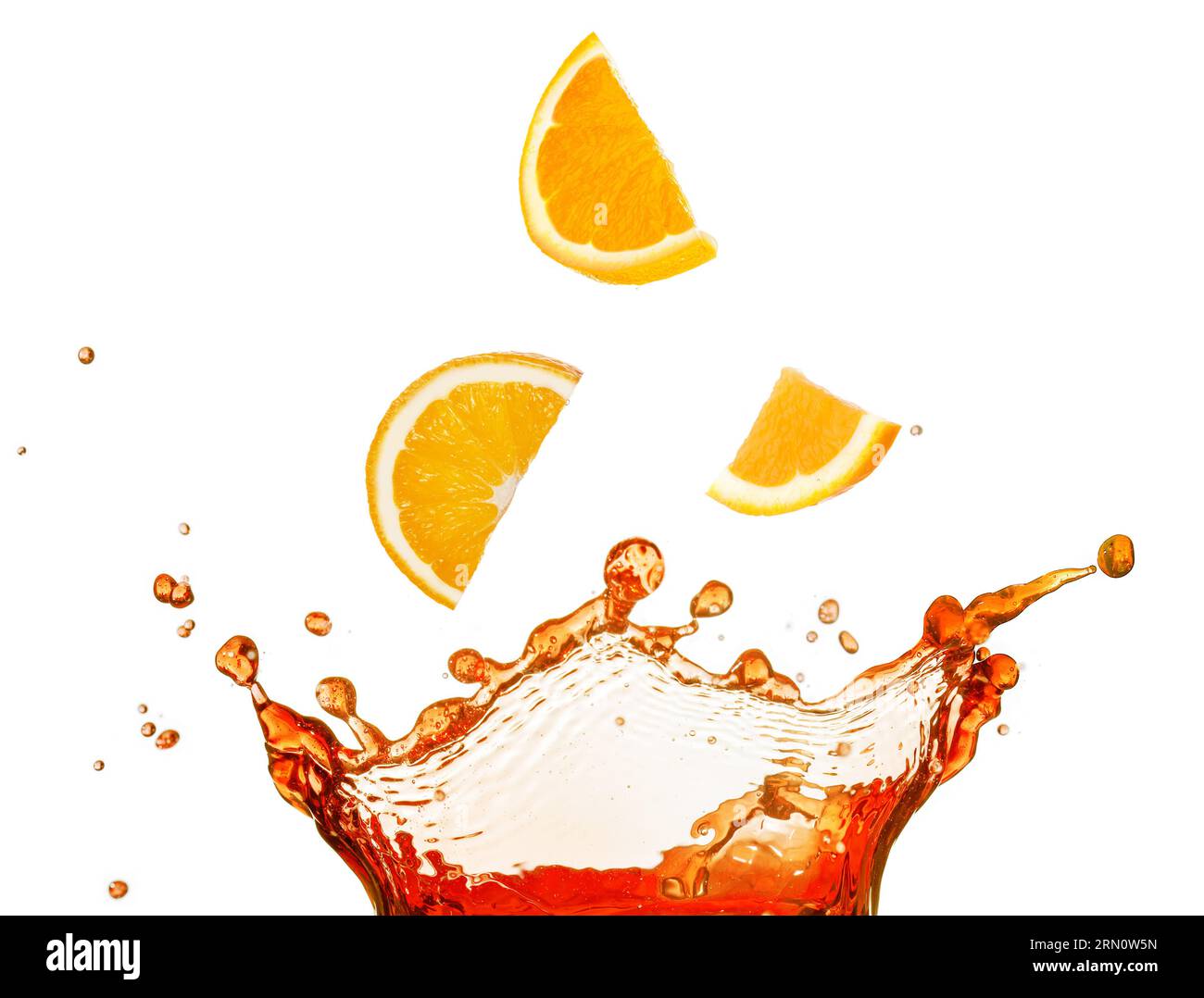 Orangenscheiben, die in flüssiges Spritzwasser fallen, isoliert auf weißem Hintergrund. Reales Bild. Stockfoto