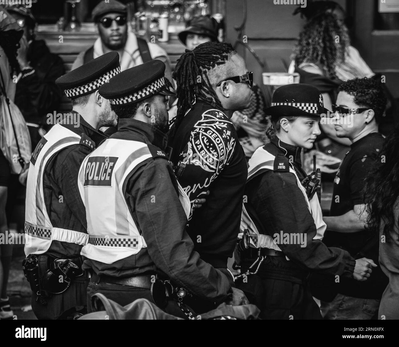 Die Polizei führte einen Verdächtigen beim Notting Hill Carnival in London weg. Stockfoto
