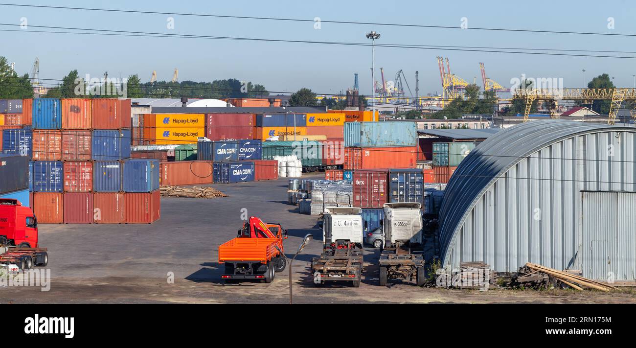 St-Petersburg, Russland - 9. August 2022: Containerterminal mit Lagergebäuden, LKWs und gestapelten Frachtcontainern, Hafenviertel Stockfoto