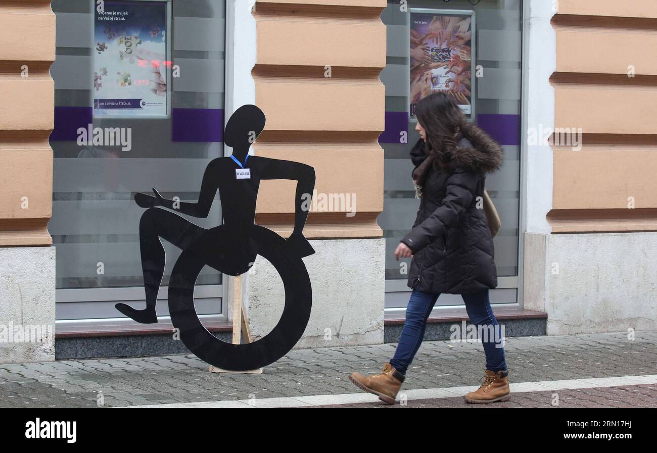 AKTUELLES ZEITGESCHEHEN Welttag der Menschen mit Behinderung (141203) -- BANJA LUKA, Eine Frau, läuft am 3. Dezember 2014 an einer Kunstrate vorbei, die eine Person mit einem Rollstuhl auf der Straße von Banja Luka, Bosnien und Herzegowina, darstellt. Am Mittwoch findet der Internationale Tag der Menschen mit Behinderungen statt, um ein Verständnis für Behindertenfragen zu fördern und die Unterstützung für die würde, die Rechte und das Wohlergehen von Menschen mit Behinderungen zu mobilisieren. ) (Djj) BOSNIEN UND HERZEGOWINA-BANJA LUKA-INTERNATIONALER TAG DER MENSCHEN MIT BEHINDERUNG BorislavxZdrinja PUBLICATIONxNOTxINxCHN Nachrichten aktuelle Ereignisse Welt die PEO Stockfoto