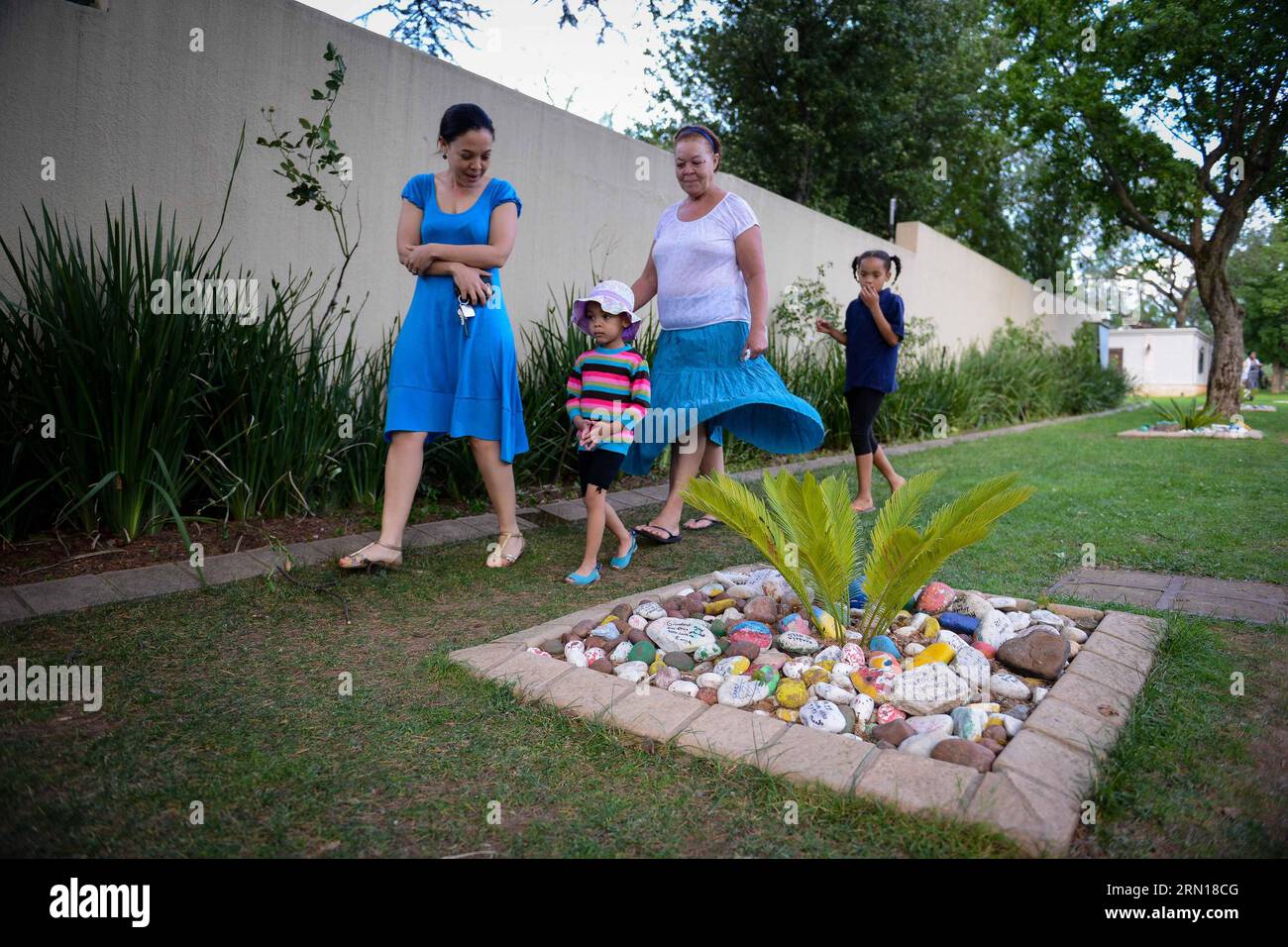 (141205) -- JOHANNESBURG, 5. Dezember 2014 -- Menschen gehen an den Steinen vorbei, wo Trostwörter vor Nelson Mandelas Residenz in Johannesburg, Südafrika, am 5. Dezember 2014 geschrieben werden können. Die Menschen gingen in die Residenz des verstorbenen südafrikanischen Präsidenten Nelson Mandela in Houghton, wo er am 5. Dezember 2013 in Johannesburg, Südafrika, verstarb, um ihr Beileid zum Ausdruck zu bringen und an den 1. Jahrestag des Todes Nelson Mandelas zu gedenken. SÜDAFRIKA-JOHANNESBURG-MANDELA-JAHRESTAG-TOD-GEDENKEN ZhaixJianlan PUBLICATIONxNOTxINxCHN Johannesburg DEC 5 2014 Prominente gehen vorbei Stockfoto