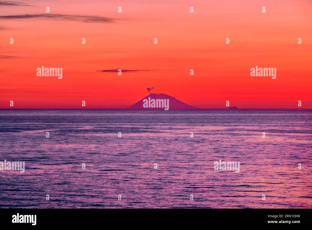 Roter Himmel nach Sonnenuntergang über der Vulkaninsel Stromboli, von Tropea aus gesehen. Stockfoto