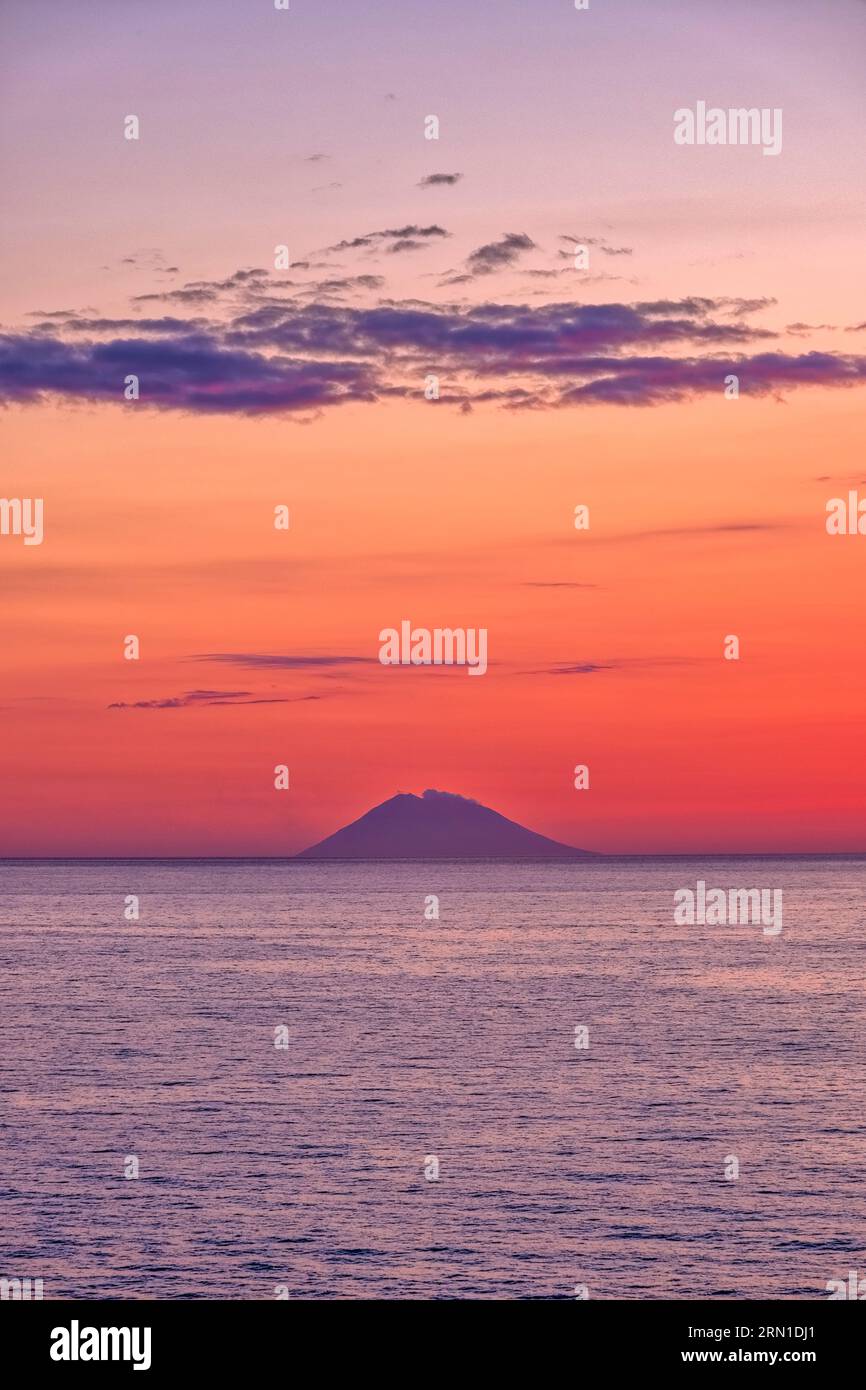 Roter Himmel nach Sonnenuntergang über der Vulkaninsel Stromboli, von Tropea aus gesehen. Stockfoto