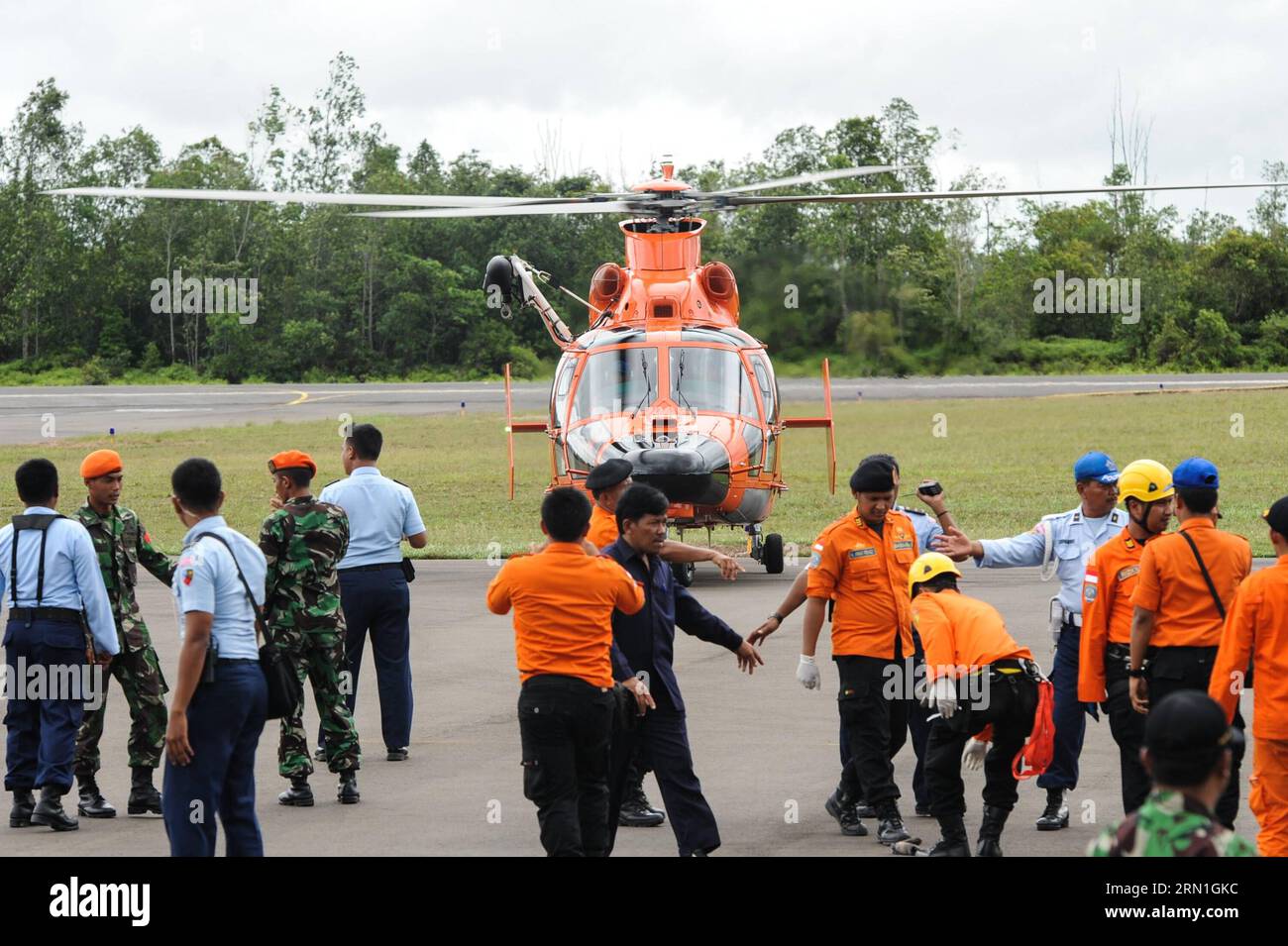 Absturz von AirAsia-Flug QZ8501 - Opfer werden geborgen Menschen versammeln sich um einen Hubschrauber, der Leichen von Opfern auf AirAsia-Flug QZ8501 auf dem Luftwaffenstützpunkt Iskandar in Pangkalan Bun, Zentral-Kalimantan, Indonesien, Dezember 31, bringt. 2014. indonesische Rettungskräfte, die nach dem vermissten Flugzeug von AirAsia suchen, haben sechs Leichen entdeckt und drei aus Gewässern vor der Südküste der Insel Kalimantan geborgen, kurz nachdem sie schwimmende Trümmer beobachteten, die später bestätigt wurden, dass sie von dem unglückseligen Flugzeug stammen. ) INDONESIEN-PANGKALAN BUN-AIRASIA-OPFER VerixSanovri PUBLICATIONxNOTxINxCHN Absturz von AirAsia Flight Vict Stockfoto