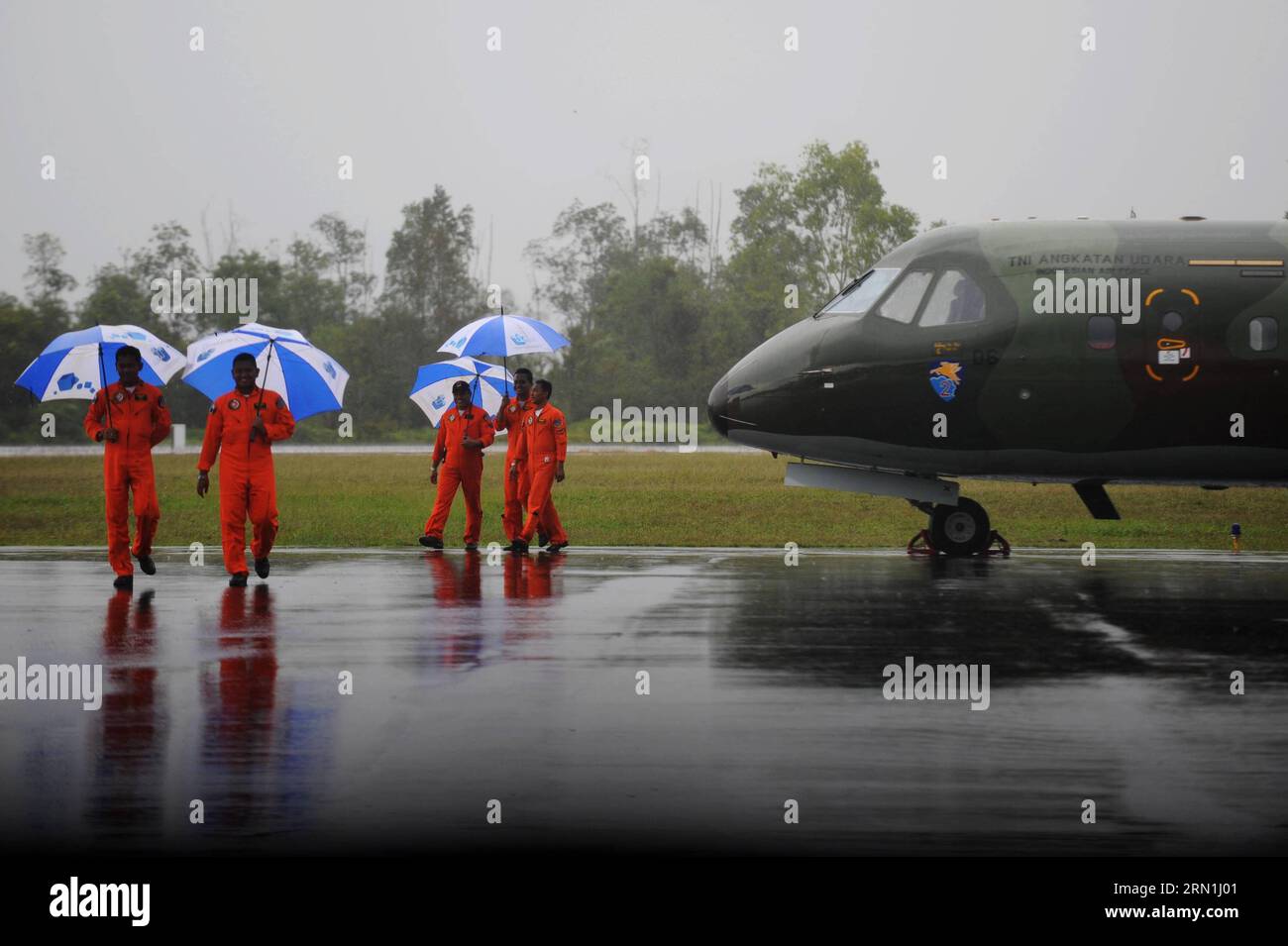 AKTUELL ZEITGESCHEHEN Absturz von AirAsia-Flug QZ8501 - schlechtes Wetter erschwert Suche nach Flugschreiber (150104) -- PANGKALAN BUN, 4. Januar 2015 -- indonesische Luftwaffenpiloten halten Regenschirme bei starkem Regen, während ihr Flugzeug am 4. Januar 2015 in Pangkalan Bun, Indonesien, abgesagt wird. Das Such- und Rettungsteam muss noch die schwarzen Boxen des abgestürzten AirAsia-Fluges QZ8501 finden, da noch immer schlechtes Wetter auf der Absturzstelle herrscht, sagte ein indonesischer Beamter hier am Samstag. ) INDONESIEN-PANGKALAN BUN-AIRASIA-SCHWERER REGEN AGUNGXKUNCAHYAXB. PUBLICATIONxNOTxINxCHN News aktuelle Ereignisse Crash From Air Stockfoto