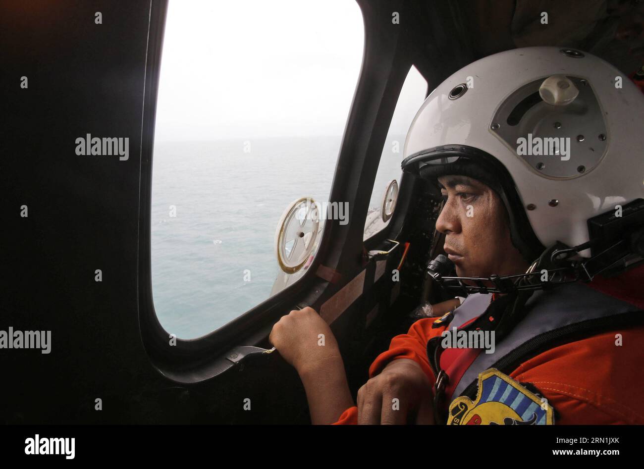 (150106) -- PANGKALAN BUN, 6. Januar 2015 -- Ein Besatzungsmitglied eines Helikopters der indonesischen Luftwaffe NAS 332 Super Puma schaut aus dem Fenster während einer Suchoperation nach den Opfern von AirAsia QZ 8501 über dem Java-Meer vor Pangkalan Bun, Indonesien, 6. Januar 2015. Die Suchaktion für AirAsia-Flug QZ8501 wird sich am Dienstag leicht nach Osten ausbreiten, da das Wetter und die Strömungen Trümmer in diese Richtung ziehen, sagte der Leiter der indonesischen Rettungsagentur. /Achmad Ibrahim) INDONESIA-PANGKALAN BUN-AIRASIA-SEARCH Pool PUBLICATIONxNOTxINxCHN Pangkalan Bun Jan 6 2015 ein Besatzungsmitglied von to Indonesia Air Stockfoto