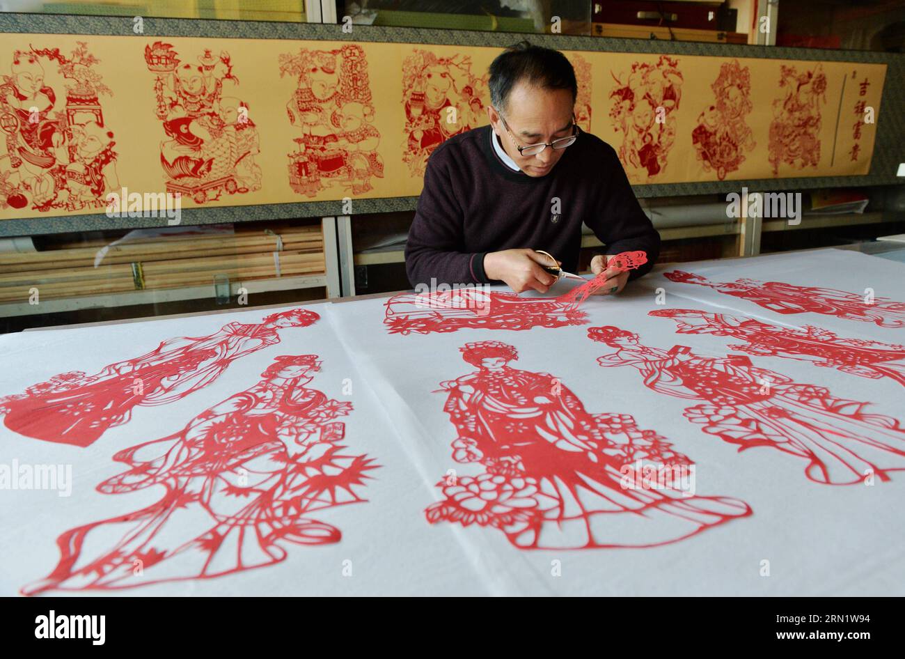 HEJIAN, 21. Januar 2015 -- der Volkskünstler Song Baoshu macht in Hejian City, nordchinesische Provinz Hebei, 21. Januar 2015. Mit einer Schere und etwas Papier können chinesische Handwerker Papierschnitte mit komplexen Designs und Bildern erstellen. Als das Papercutting im Blut läuft, widmet sich der 61-jährige Song Baoshu der Erhaltung des Papercutts. (wh) CHINA-HEBEI PROVINCE-HEJIAN-PAPERCUTTINGS(CN) ZhuxXudong PUBLICATIONxNOTxINxCHN Hejian Jan 21 2015 Volkskünstler Song Baoshu macht in Hejian City Nordchina S Hebei Province Jan 21 2015 mit einem Paar Schere und etwas Papier, das Chinese erstellen KANN Stockfoto