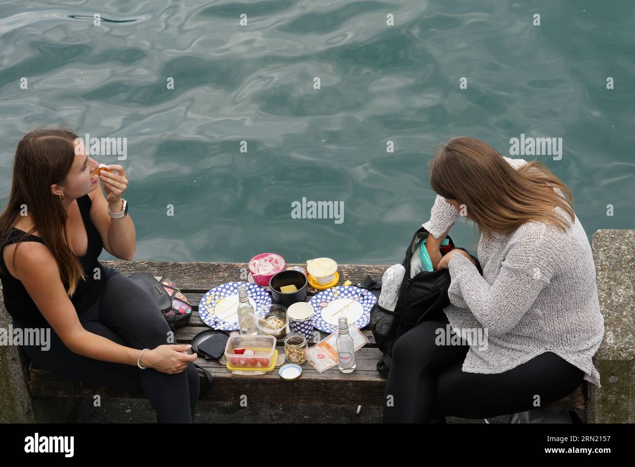 Zwei junge Frauen machen ein Picknick am Zürichsee. Stockfoto