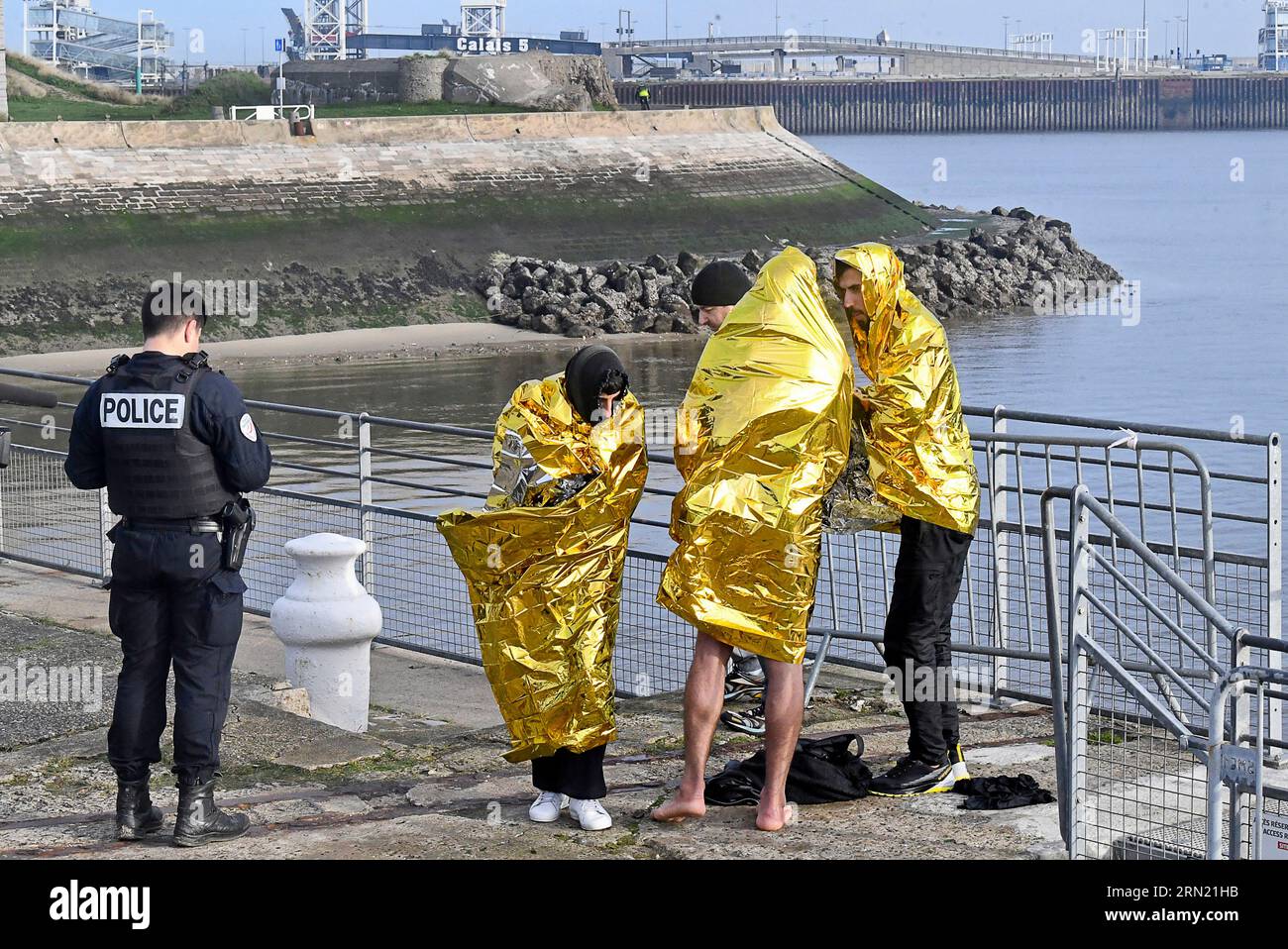 Calais, 13. November 2022 (Nordfrankreich): Drei Migranten, die während einer Kanalüberquerung nach Großbritannien auf See gerettet wurden. Migrantinnen mit Überlebensdecken Stockfoto