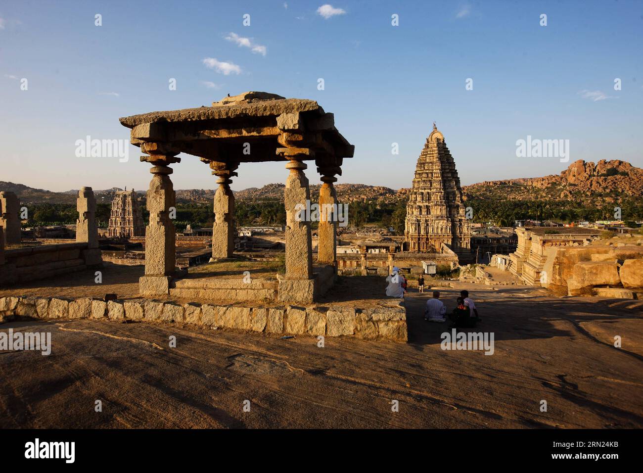 Touristen besuchen den Virupaksha-Tempel und seine umliegenden Gebäude in Hampi im Bellary District von Indiens Bundesstaat Karnataka, 6. Februar 2015. Hampi ist die letzte Hauptstadt des letzten großen Hindureiches Vijayanagar. Die fabelhaft reichen Fürsten errichteten dravidische Tempel und Paläste, die zwischen dem 14. Und 16. Jahrhundert die Bewunderung der Reisenden gewannen. Die Stadt, die 1565 von der muslimischen Konföderation der Dekkaner erobert wurde, wurde über einen Zeitraum von sechs Monaten geplündert, bevor sie aufgegeben wurde. Die Gruppen von Denkmälern in Hampi wurden als t eingetragen Stockfoto