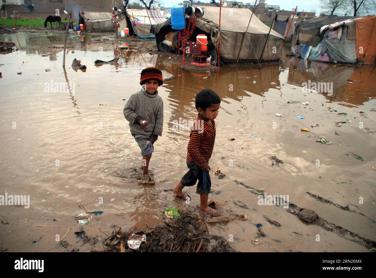 (150303) -- CHARSADDA, 3. März 2015 -- pakistanische Jungen laufen am 3. März 2015 im Regenwasser des nordwestlichen pakistanischen Charsadda. Mindestens 10 Menschen, darunter drei Kinder, wurden getötet und mehrere andere wurden am Montag bei separaten regenbedingten Vorfällen in Pakistan verletzt, berichtete ein lokaler Arzt. ) PAKISTAN-CHARSADDA-RAIN UmarxQayyum PUBLICATIONxNOTxINxCHN Charsfield Adda 3. März 2015 Pakistanische Jungen laufen im Regenwasser im Nordwesten Pakistans S Charsfield Adda AM 3. März 2015 wurden mindestens 10 Prominente, darunter drei Kinder, GETÖTET und mehrere andere bei separaten Vorfällen im ZUSAMMENHANG MIT DEM Regen verletzt Stockfoto