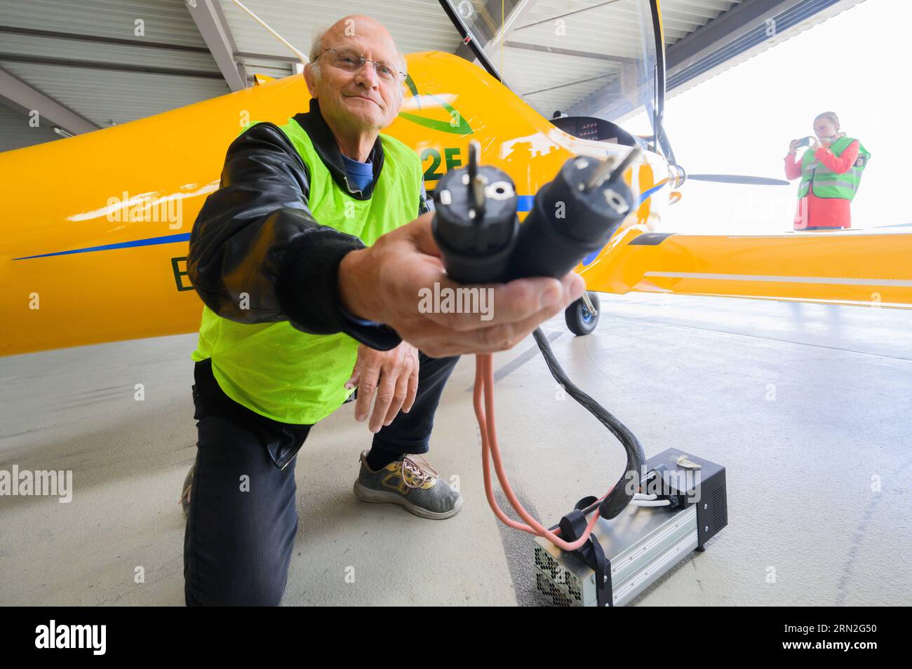 Hannover, Deutschland. August 2023 31. Testpilot Uwe Nortmann zeigt einen Spannungswandler vor dem E-Flugzeug „Elektra Trainer“ am Flughafen Hannover. Das Ultraleichtflugzeug des Herstellers Elektra Solar GmbH landete als erstes E-Flugzeug am Mittwochabend auf dem größten Flughafen Niedersachsens. Nach Expertenmeinungen könnten Geschäfts- und Urlaubsflüge in nur wenigen Jahren klimaneutral sein. Quelle: Julian Stratenschulte/dpa/Alamy Live News Stockfoto