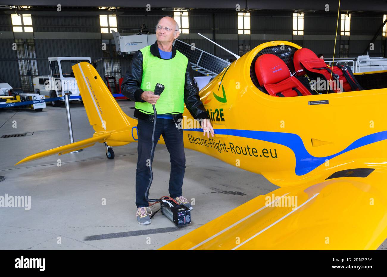 Hannover, Deutschland. August 2023 31. Testpilot Uwe Nortmann steht mit einem Spannungswandler vor dem E-Flugzeug „Elektra Trainer“ am Flughafen Hannover. Das Ultraleichtflugzeug des Herstellers Elektra Solar GmbH landete als erstes E-Flugzeug am Mittwochabend auf dem größten Flughafen Niedersachsens. Nach Expertenmeinungen könnten Geschäfts- und Urlaubsflüge in nur wenigen Jahren klimaneutral sein. Quelle: Julian Stratenschulte/dpa/Alamy Live News Stockfoto