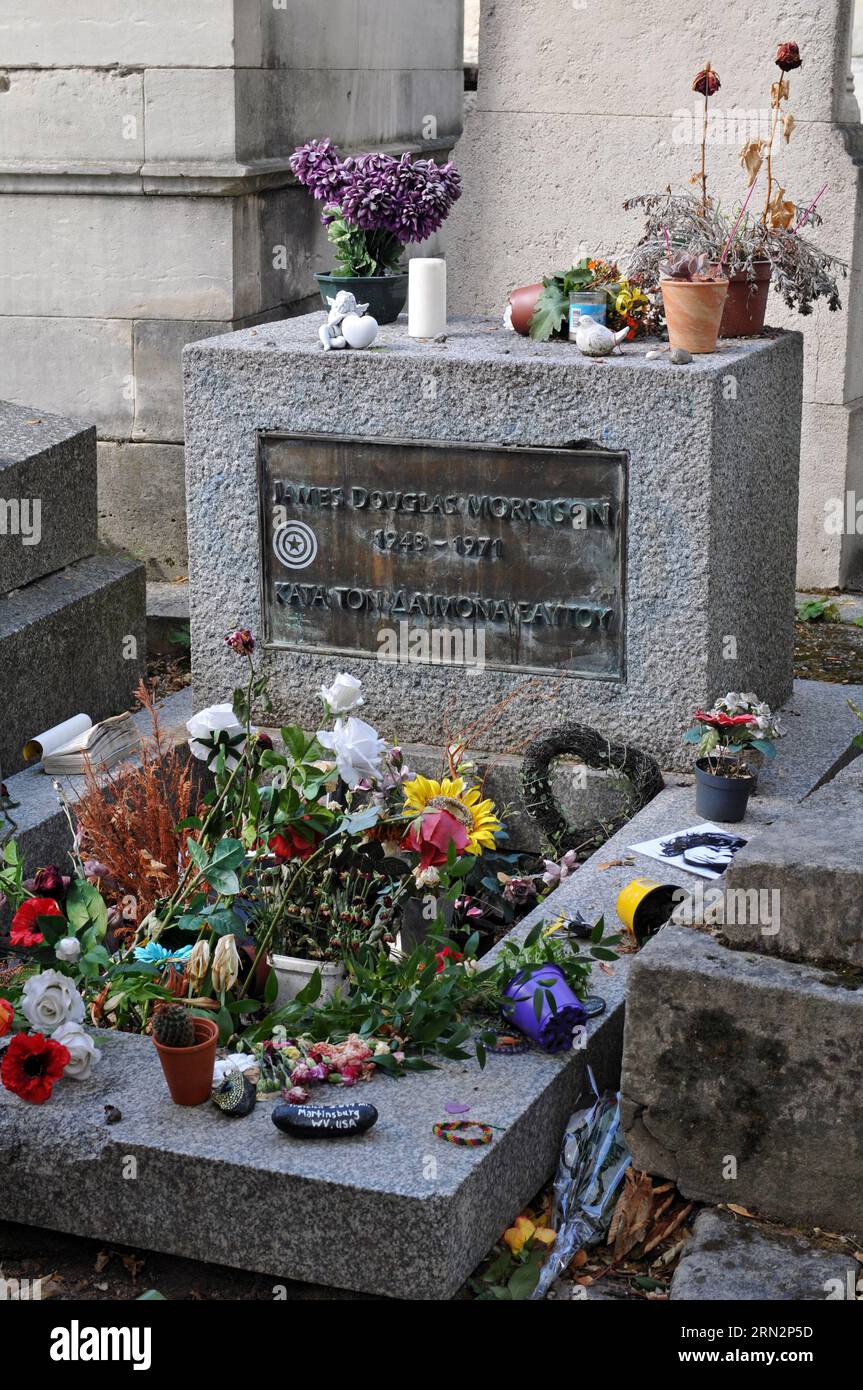 Das Grab von Jim Morrison, Sänger der Rockband The Doors, mit Blumen und anderen Gegenständen, die von Fans auf dem Pariser Friedhof Père Lachaise hinterlassen wurden. Stockfoto