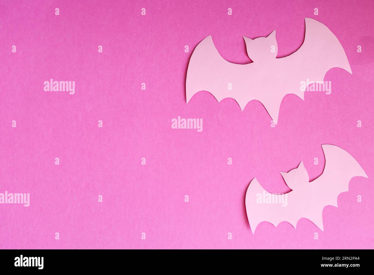 Pastellrosa Fledermäuse auf rosafarbenem Papierhintergrund halloween-Konzept Stockfoto