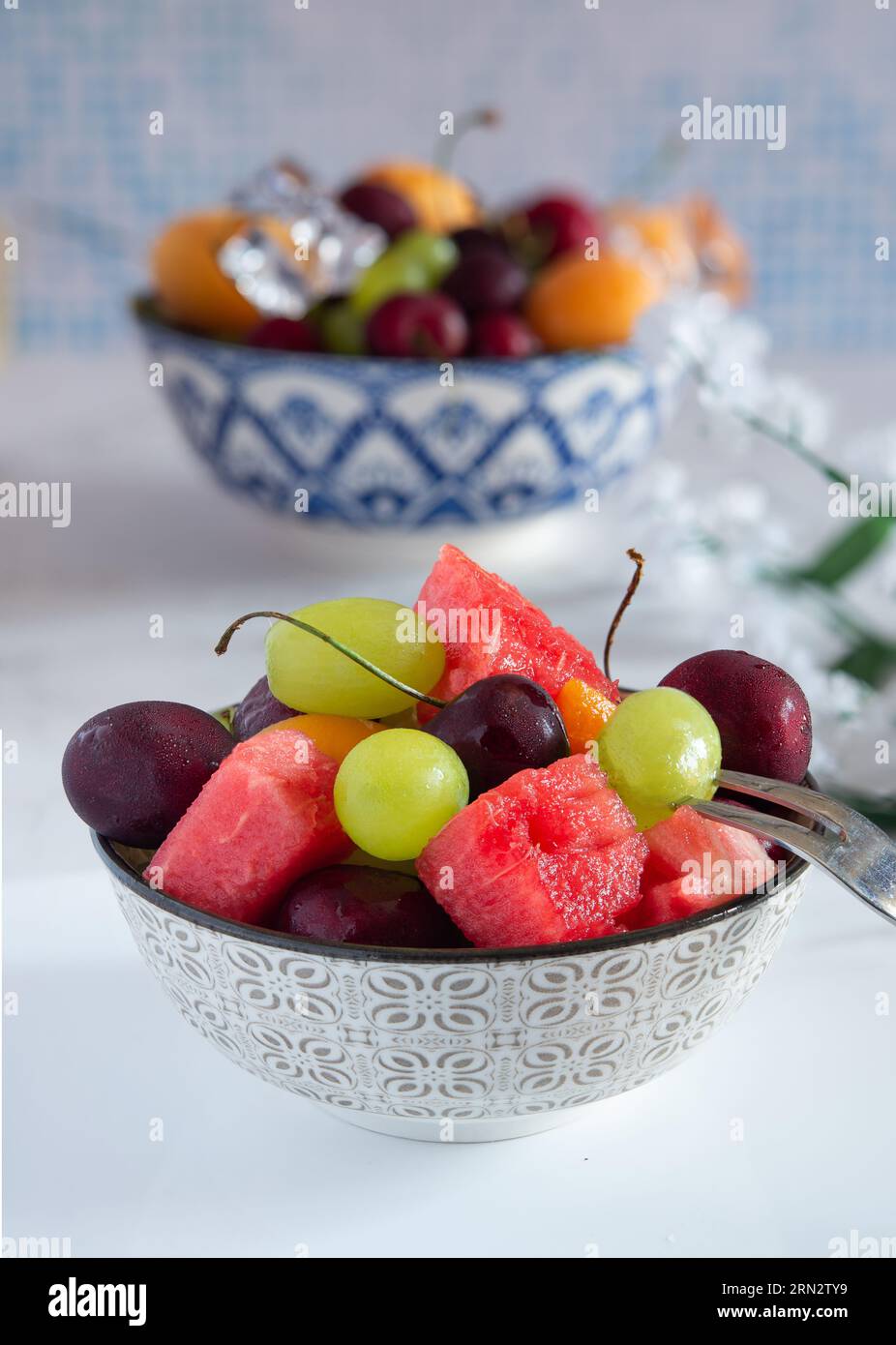 Tasse mit kaltem Wasser und frischem Sommerobst mit Eis Stockfoto