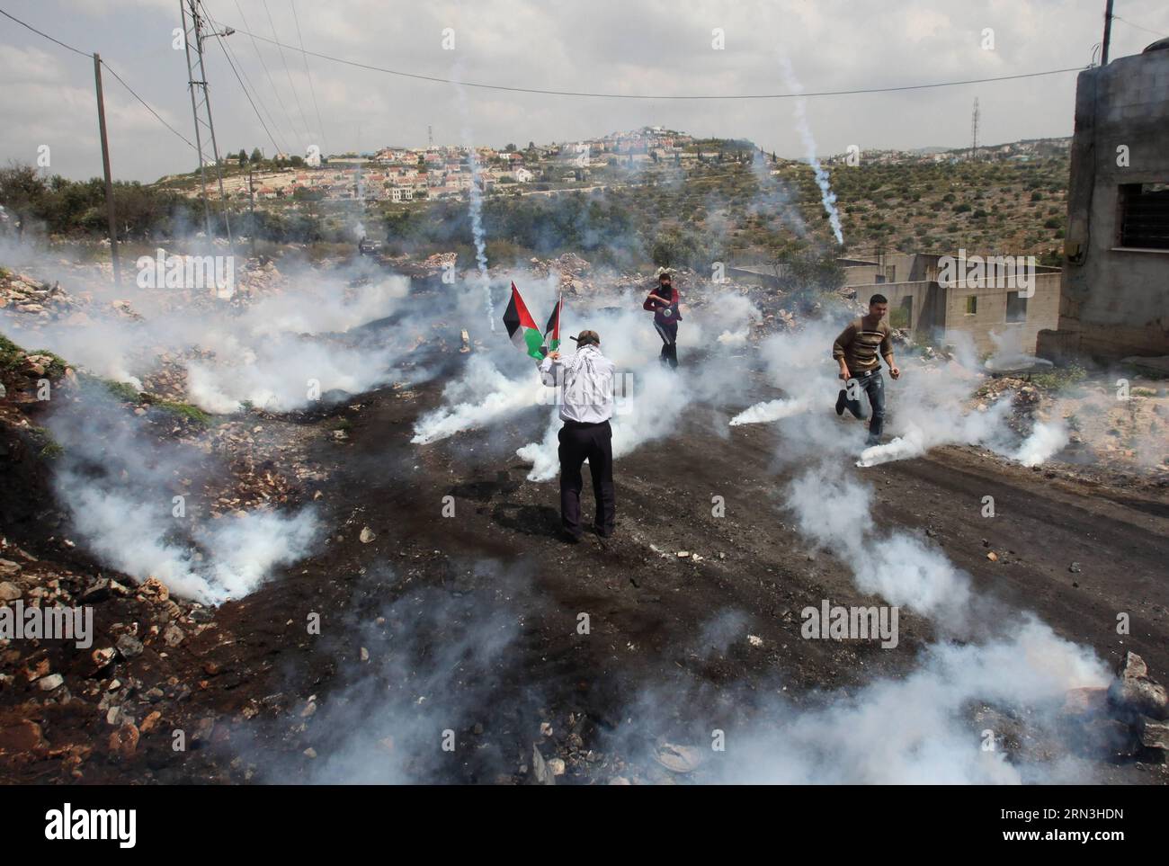 (150417) - NABLUS, 17. April 2015 - Ein palästinensischer Demonstrant läuft in Deckung, um sich vor einem Tränengaskanister zu schützen, der von Israelis während der Auseinandersetzungen nach einem Protest anlässlich des Tages der palästinensischen Gefangenen im Dorf Kafr Qaddum in der Nähe der Westbank-Stadt Nablus am April erschossen wurde. 17, 2015. Offizielle Zahlen zeigen, dass 6.500 Palästinenser in israelischen Gefängnissen und Gefängnissen inhaftiert sind, darunter 30, die seit mehr als 25 Jahren inhaftiert sind. Seit 1974, am 17. April jedes Jahres, jähren sich die Palästinenser zum Jahrestag des palästinensischen Gefangenentages. Nidal Eshtayeh) MIDEAST-NABLUS-CLASHES EmadxDrimly PUBLICATIONxN Stockfoto