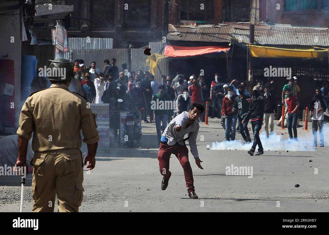(150417) -- SRINAGAR (INDIEN), 17. April 2015 -- Ein Kashmiri-Demonstrant wirft ein Stück Ziegel auf einen indischen Polizisten während eines Protestes in der Innenstadt von Srinagar, der Sommerhauptstadt des von Indien kontrollierten Kaschmirs, am 17. April 2015. Die Regierungstruppen in dem von Indien kontrollierten Kaschmir feuerten am Freitag Warnschüsse und Dutzende von Tränenrauchgranaten ab, um Hunderte von wütenden Demonstranten zu zerstreuen, die vor einer Kundgebung gegen Separatisten demonstrierten, um den Tod eines Jugendlichen zu betrauern. ) INDIEN-KASCHMIR-SRINAGAR-PROTEST-CLASHES JavedxDar PUBLICATIONxNOTxINxCHN Srinagar Indien 17. April 2015 A KASCHMIR wirft A Stockfoto