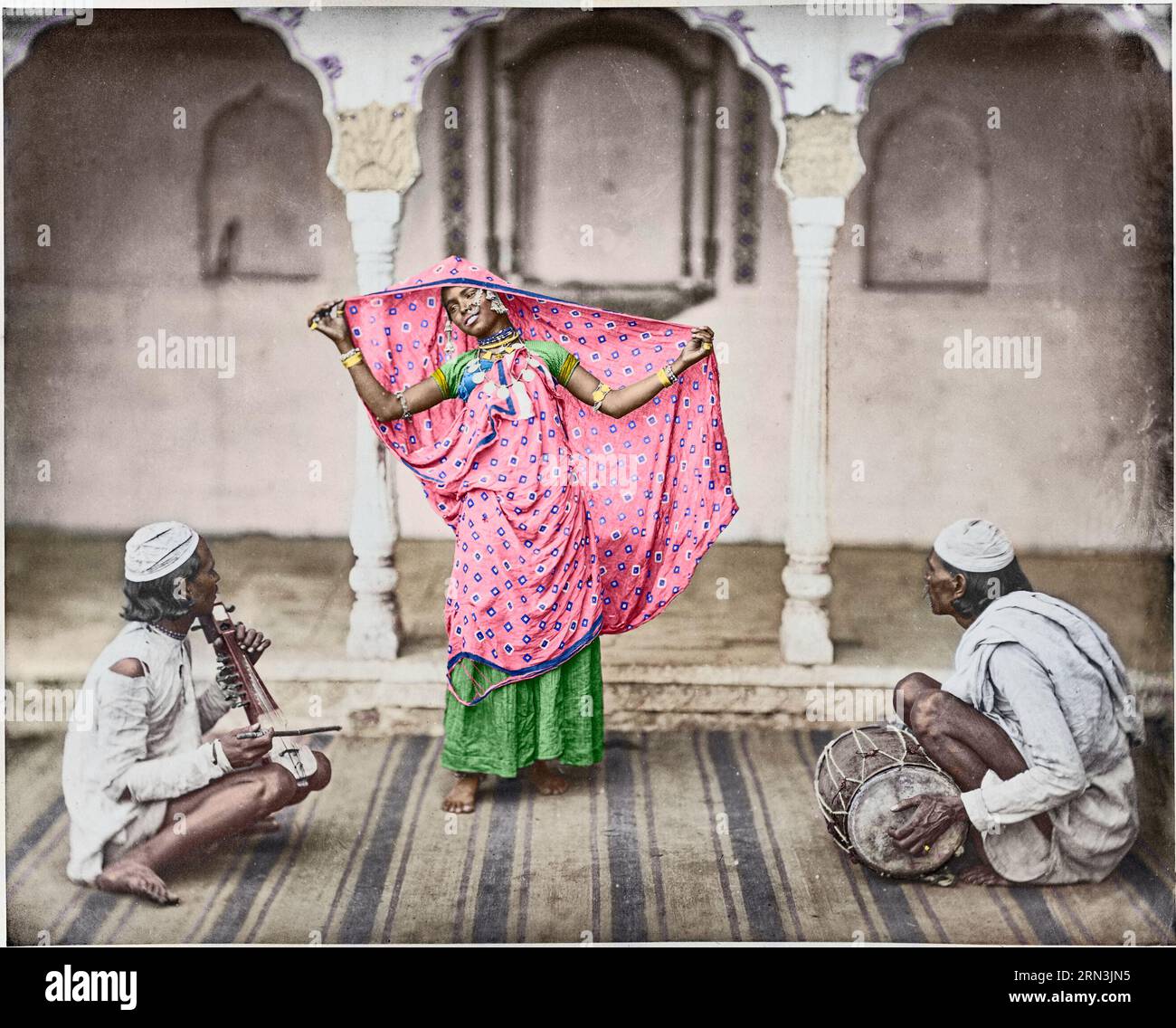Nautch - Mädchen. 1862. Eine gebürtige Frau posiert mit ihrem Sari und spreizt ihn auf dem Kopf, möglicherweise als Teil einer Tanzvorstellung. Zwei begleitende männliche Mu Stockfoto