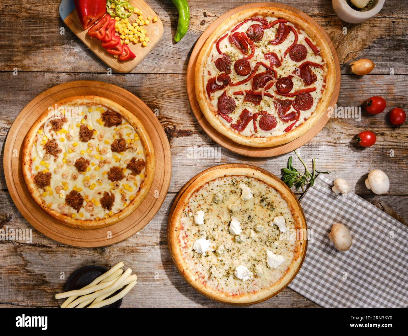 Pizza-Fotoshooting mit Top- und Seitenaufnahmen Pizza auf Holzbrett. Top-Down-Shooting, Appetitlicher Hintergrund. Einige Pizzas im Hintergrund. Aus Holz. Stockfoto