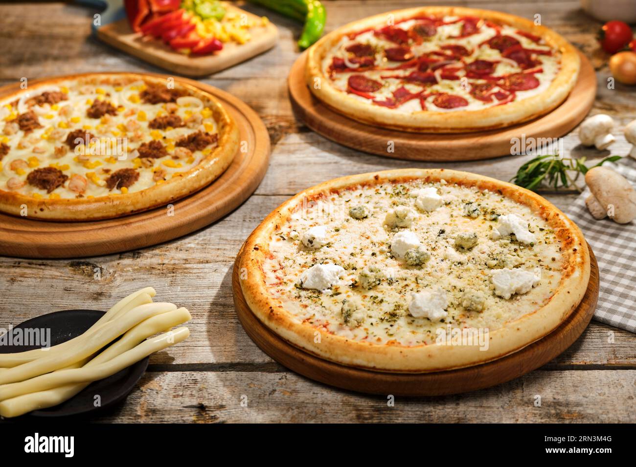 Pizza-Fotoshooting mit Top- und Seitenaufnahmen Pizza auf Holzbrett. Top-Down-Shooting, Appetitlicher Hintergrund. Einige Pizzas im Hintergrund. Aus Holz. Stockfoto