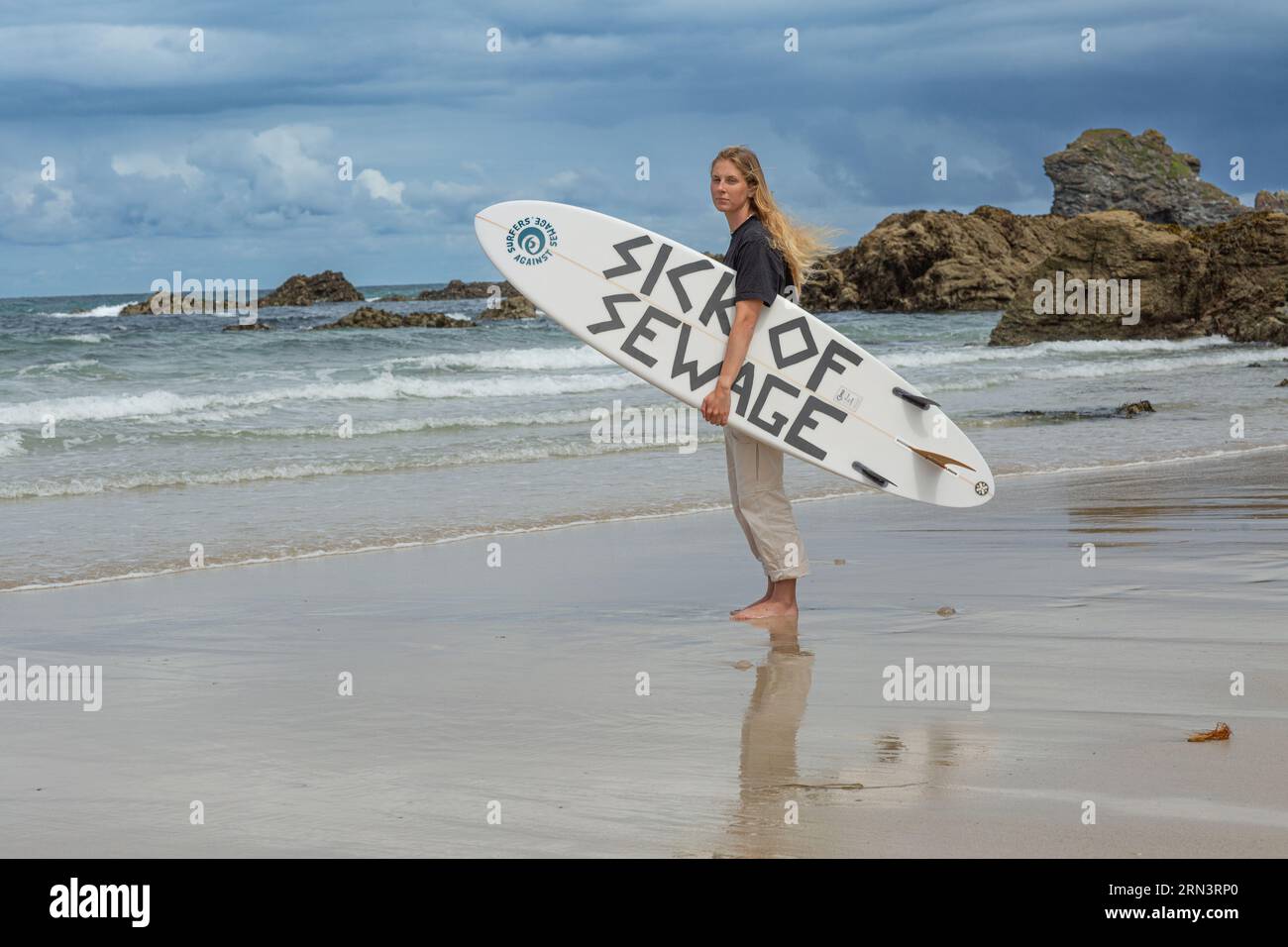 Surfer Against Sewage Tabitha McCormick Surfboard mit dem SLOGAN „SICK OF SEWAGE“. Trevaunance Cove, St Agnes, Cornwall, UK Stockfoto