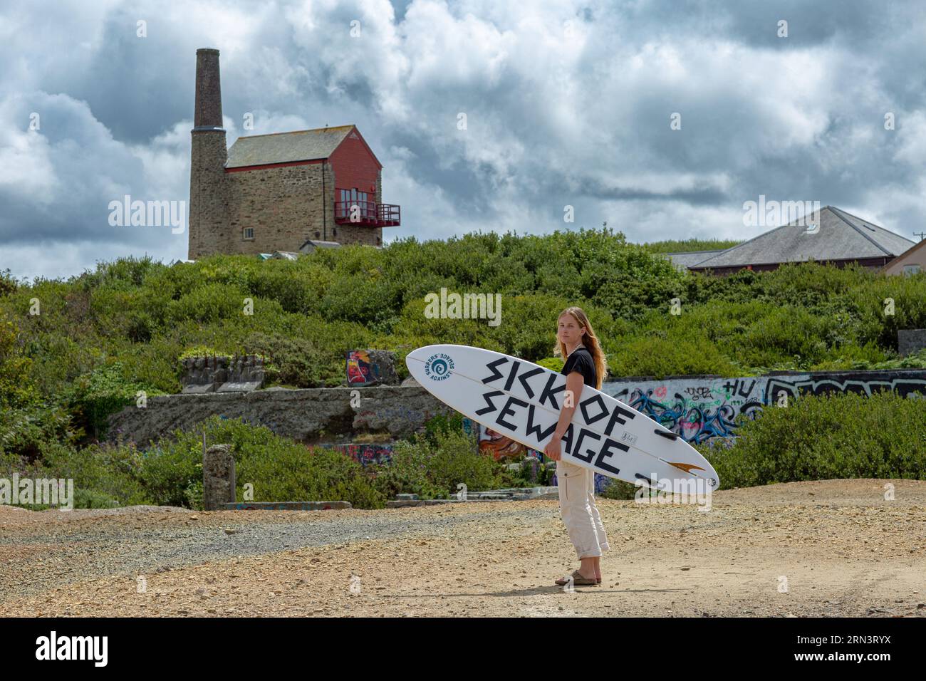 Surfer Tabitha McCormick Surf Board mit dem SLOGAN „SICK OF SEWAGE“ und Surfer Against Sewage HQ in St Agnes, Cornwall, UK Stockfoto