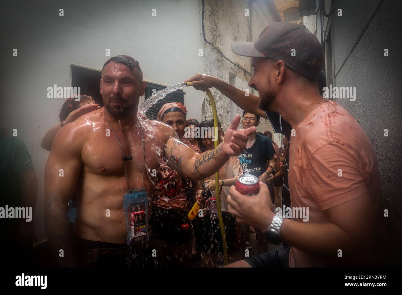 Valencia, Spanien. 30. August 2023. Ein Mann versucht, zerstoßene Tomaten von einem Teilnehmer am tomatina-Festival zu entfernen. Ein weiteres Jahr, wie jeden letzten Mittwoch des Monats August, wurde La Tomatina in der valencianischen Stadt Buñol in Spanien gefeiert. Ein fest, das seit mehr als 50 Jahren stattfindet und an eine Meinungsverschiedenheit zwischen den Landwirten erinnert, die mit einem Tomatenkampf endete und das traditionelle Festival begründete. Quelle: SOPA Images Limited/Alamy Live News Stockfoto
