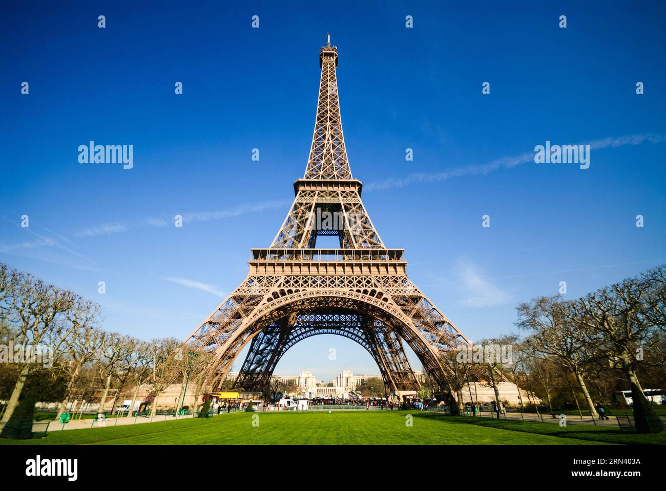 PARIS, Frankreich – Eine Weitwinkelaufnahme des Eiffelturms in Paris mit einem tiefblauen Himmel an einem Frühlingsmorgen. Diese Aufnahme stammt vom Champ de Mars. Der Eiffelturm wurde für die Weltausstellung 1889 gebaut und ist zu einem der bekanntesten Wahrzeichen der Welt geworden. Stockfoto