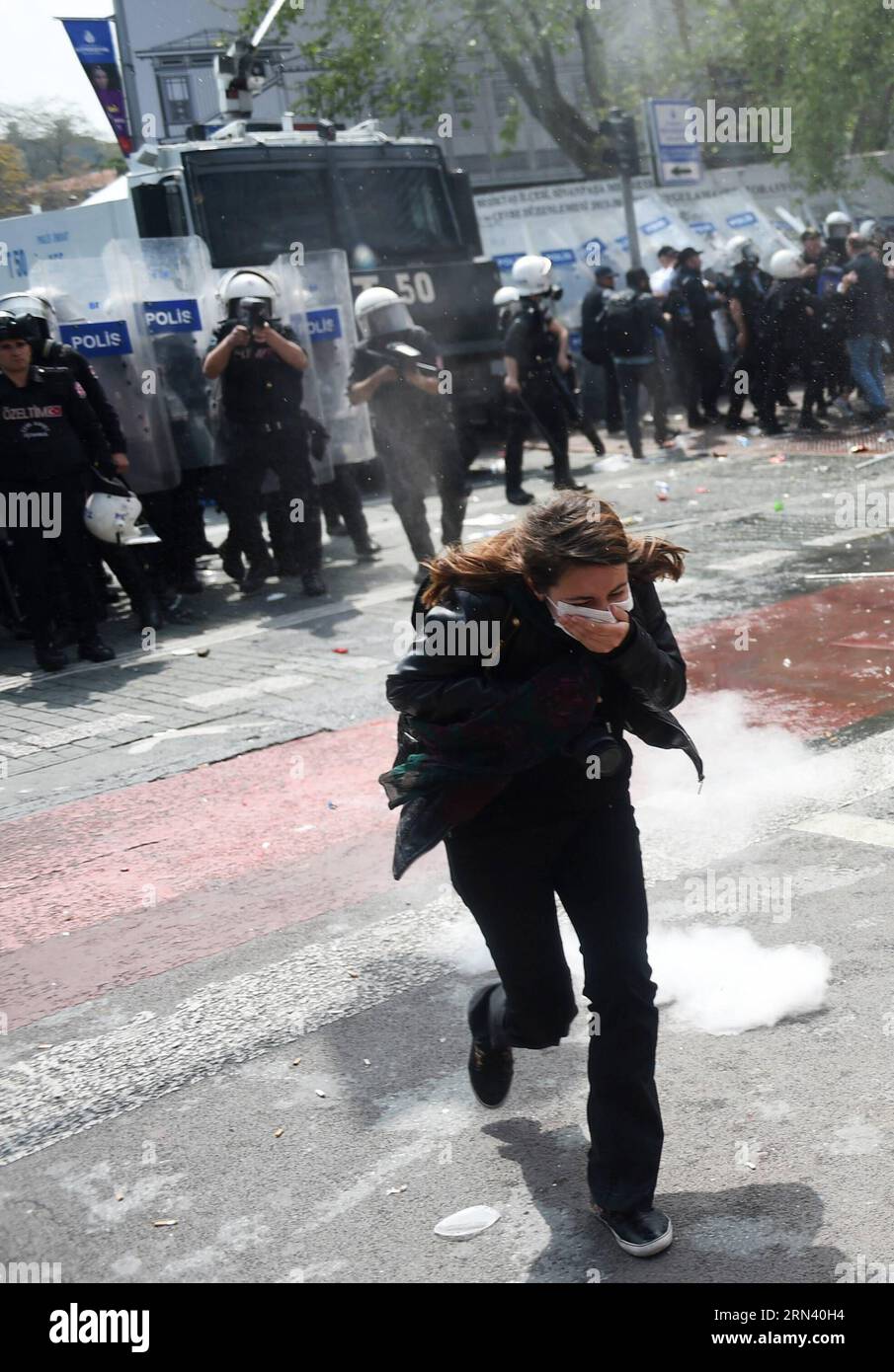 (150501) -- ISTANBUL, Mai 1,2015 -- Eine Frau bedeckt ihre Nase und ihren Mund gegen Tränengas während des maimärz in Istanbul, Türkei, 1. Mai 2015. Die türkische Aufständische Polizei feuerte am Freitag Wasserkanonen und Tränengas ab, um Demonstranten am Maitag zu zerstreuen, die vor fast 40 Jahren zum berühmten Taksim-Platz in Istanbul marschieren wollten, um dort Massenmorde an Arbeitern zu markieren. Istanbuls Sicherheitschef Selami Altinok erklärte, dass 136 Menschen inhaftiert seien. )(bxq) TÜRKEI-ISTANBUL-MAI-TAG-ZUSAMMENPRALL HexCanling PUBLICATIONxNOTxINxCHN 150501 Istanbul 1. Mai 2015 eine Frau bedeckt ihre Nase und ihren Mund gegen Tränengas während des Mai Tag M Stockfoto