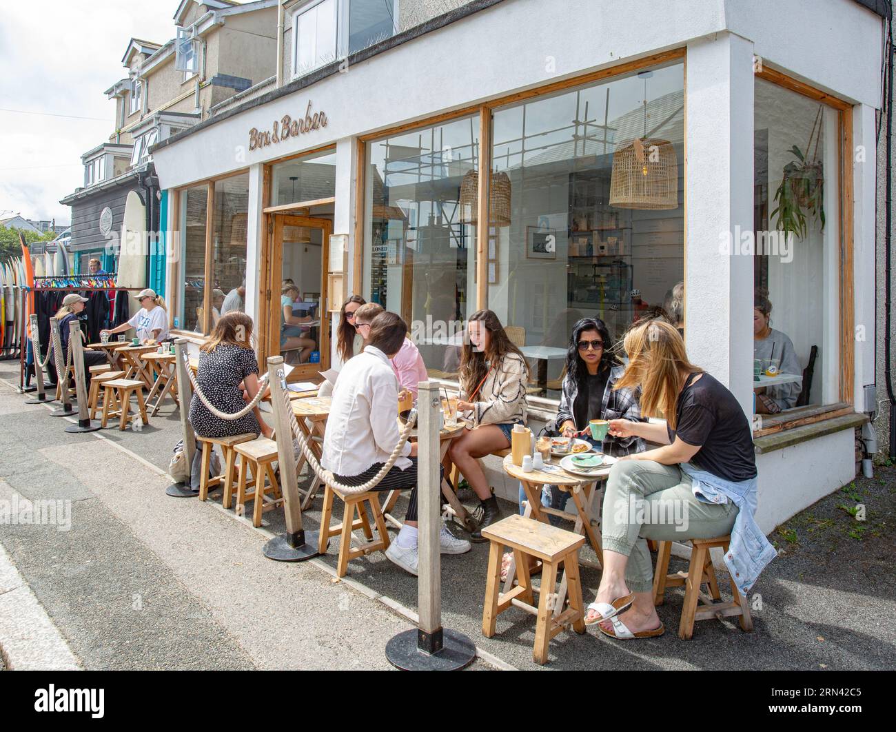 Leute sitzen vor Box und Barber Cafe in Newquay, Cornwall, Großbritannien Stockfoto