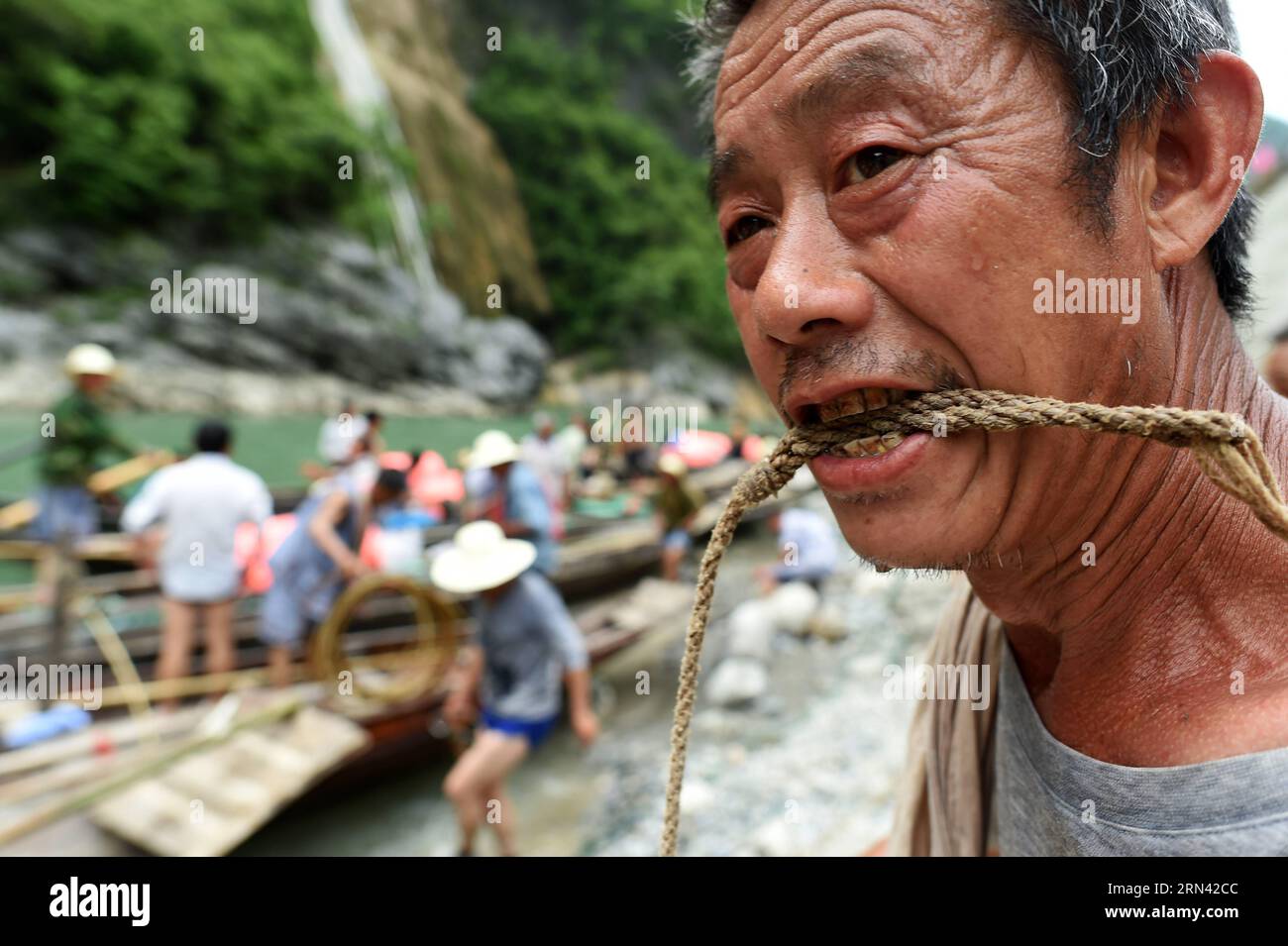 AKTUELLES ZEITGESCHEHEN Treideln - Bootsschlepper in Wuhan, China (150503) -- WUHAN, 3. Mai 2015 -- Foto aufgenommen am 30. April 2015 zeigt den Bootstracker Wu Qibiao, der die Schleppleine nach Erreichen des Endes entlang des Shennongxi-Flusses in der Provinz Badong in der zentralchinesischen Provinz Hubei nagt. Bereits in den 1950er Jahren waren die Einheimischen stark auf Bootsschlepper angewiesen, da der Verkehr recht begrenzt war. Da Shennongxi keine Zufahrt zu den Straßen hat, ist es der einzige Weg hinein und raus, und daher war es damals sehr beliebt, ein Fährtensucher zu sein. Ende der 1980er Jahre, mit neuen Straßen in den Bergen und der Entwicklung des Tourismus, viele davon Stockfoto