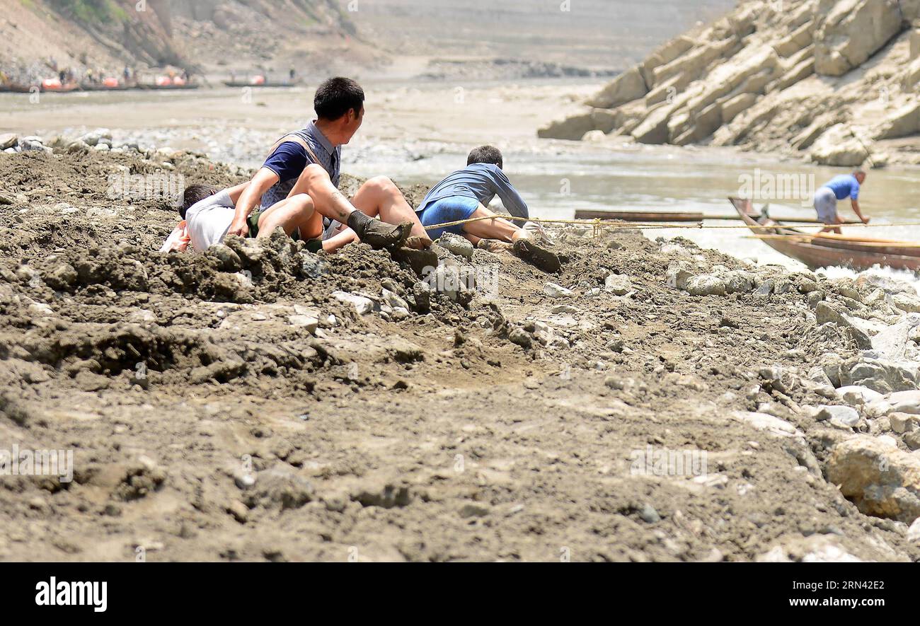 AKTUELLES ZEITGESCHEHEN Treideln - Bootsschlepper in Wuhan, China (150503) -- WUHAN, 3. Mai 2015 -- das Foto vom 30. April 2015 zeigt, wie der Bootsschlepper Shen Qianquan (2. L) über sich selbst fällt, als eine Schleppschnur brach, als er ein Boot entlang des Shennongxi-Flusses im Badong County der zentralchinesischen Provinz Hubei schleppt. Bereits in den 1950er Jahren waren die Einheimischen stark auf Bootsschlepper angewiesen, da der Verkehr recht begrenzt war. Da Shennongxi keine Zufahrt zu den Straßen hat, ist es der einzige Weg hinein und raus, und daher war es damals sehr beliebt, ein Fährtensucher zu sein. Ende der 1980er Jahre wurden neue Straßen in die Berge und in die Wüste gebaut Stockfoto
