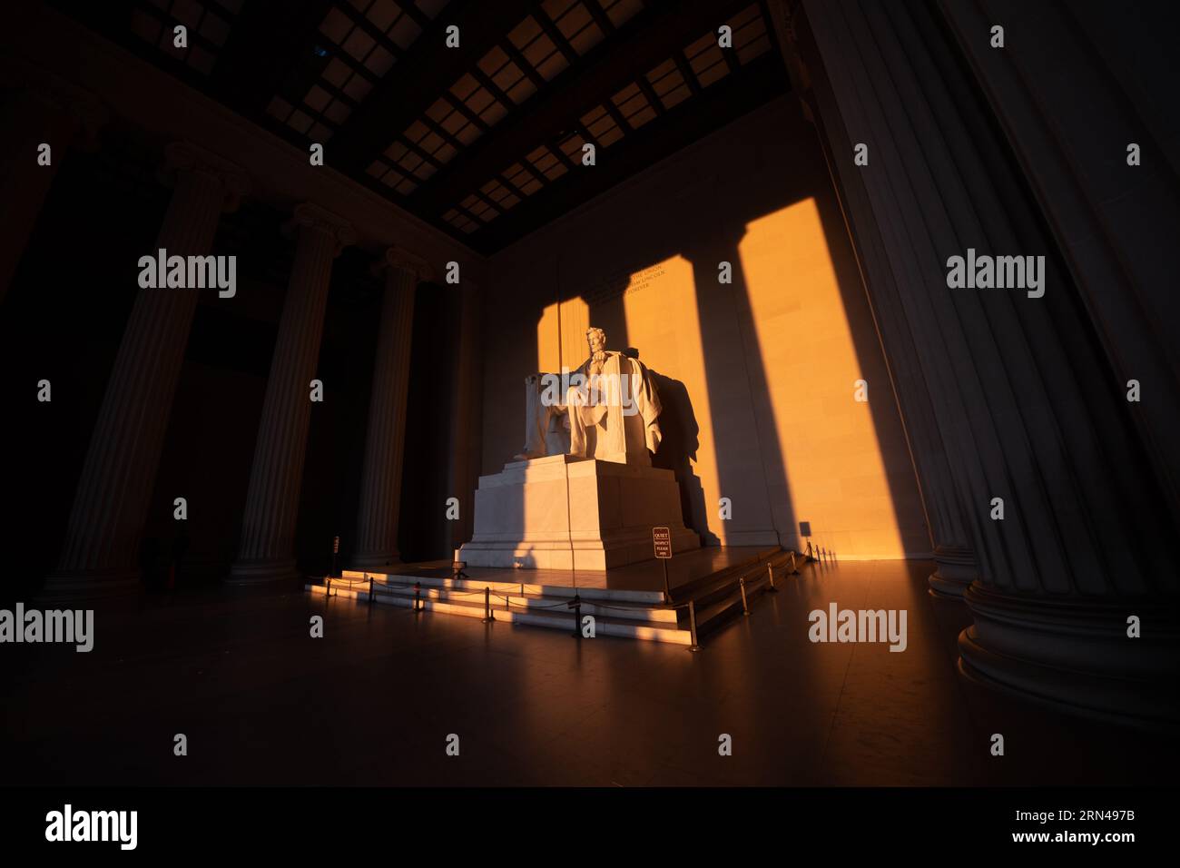 WASHINGTON DC, Vereinigte Staaten – die Statue des Lincoln Memorial, die während der Frühlingssonnenwende vom goldenen Licht des Sonnenaufgangs erleuchtet wird, strahlt ein warmes Licht über das historische Denkmal. Dieses besondere Sonnenereignis unterstreicht die ikonische Hommage an den 16. US-Präsidenten und unterstreicht Abraham Lincolns Rolle in der Geschichte der Nation. Stockfoto