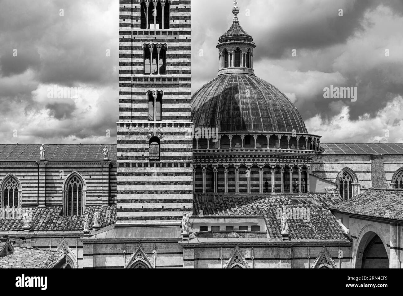 Dunkle Wolken über der Kathedrale von Siena mit ihrer schwarz-weiß gestreiften Marmorfassade, schwarz-weiß Foto, Siena, Toskana, Italien Stockfoto