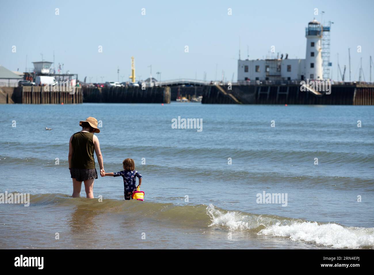 Eine Frau und ein Kind im Meer in Scarborough, Nord Yorkshire, wo das Meer unsicher ist, die Wasserqualität in Scarborough ist schlecht aufgrund der Auswirkungen von se Stockfoto