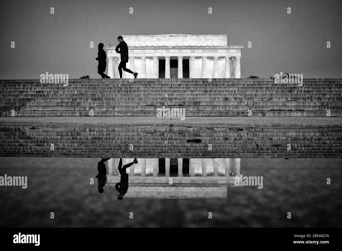 Läufer am Lincoln Memorial, Washington, D.C. Schwarzweißfoto, das die Läufer auf den Stufen mit einer Reflexion im Wasser darunter zeigt. Stockfoto