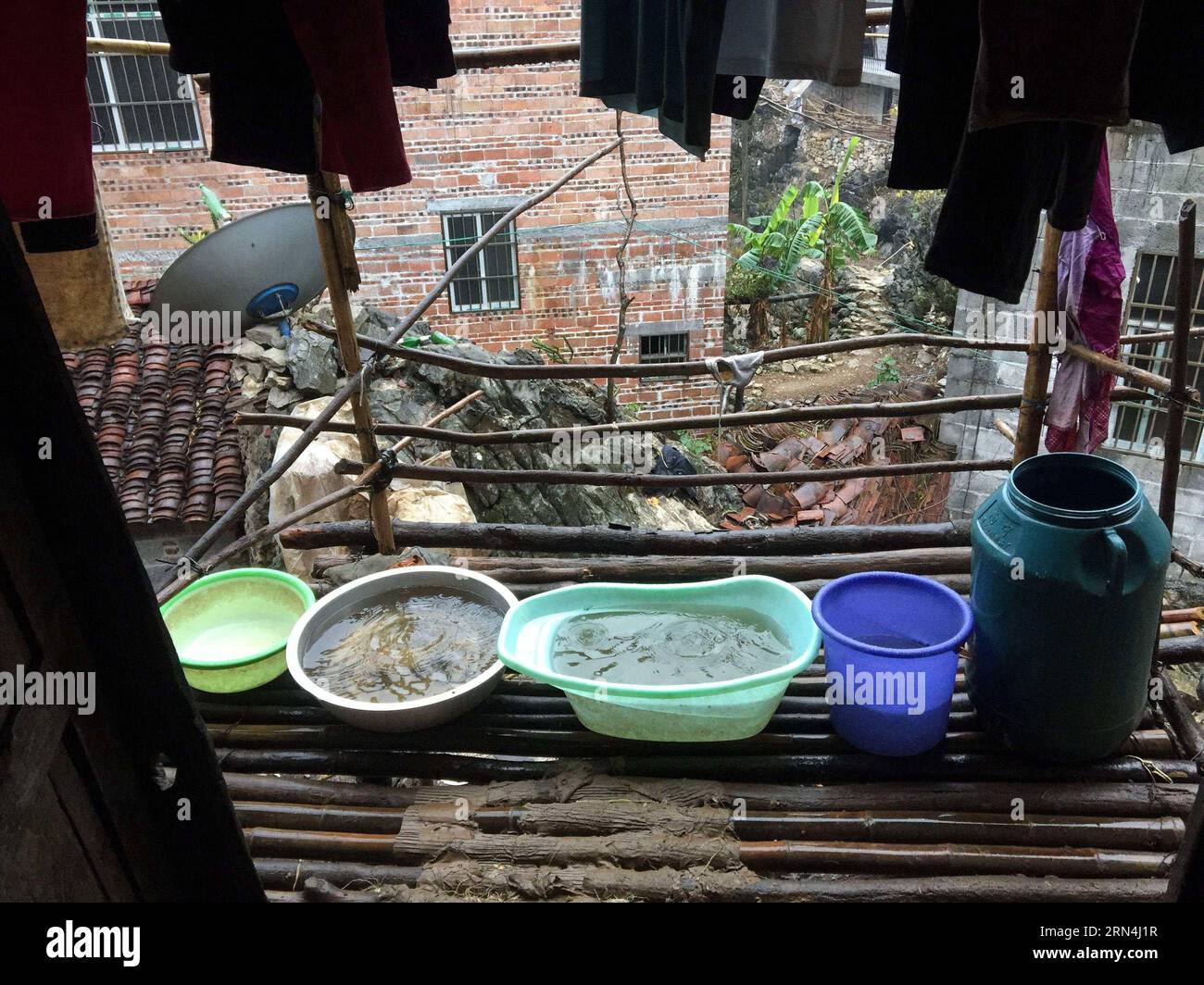 Das Regenwasser wird mit Containern in der Ortschaft Nongyong in Bansheng im Autonomen Kreis Dahua Yao, der südwestchinesischen autonomen Region Guangxi Zhuang, am 14. Februar 2015 gesammelt. Die Bansheng Township liegt im Zentrum der Karst-Landformen im Westen von Guangxi und leidet seit Ewigkeiten unter einem starken Wassermangel. Die Niederschläge sind daher ein Segen für die Menschen, die seit etwa 1.000 Jahren auf diesem Land leben und hauptsächlich der ethnischen Gruppe der Yao angehören. Um ihren täglichen Lebensbedürfnissen gerecht zu werden, sammeln die Einheimischen immer Regenwasser mit Eimern und Fässern jeder Größe sowie mit Dächern ihrer Häuser. Im letzten Jahrzehnt war Th Stockfoto